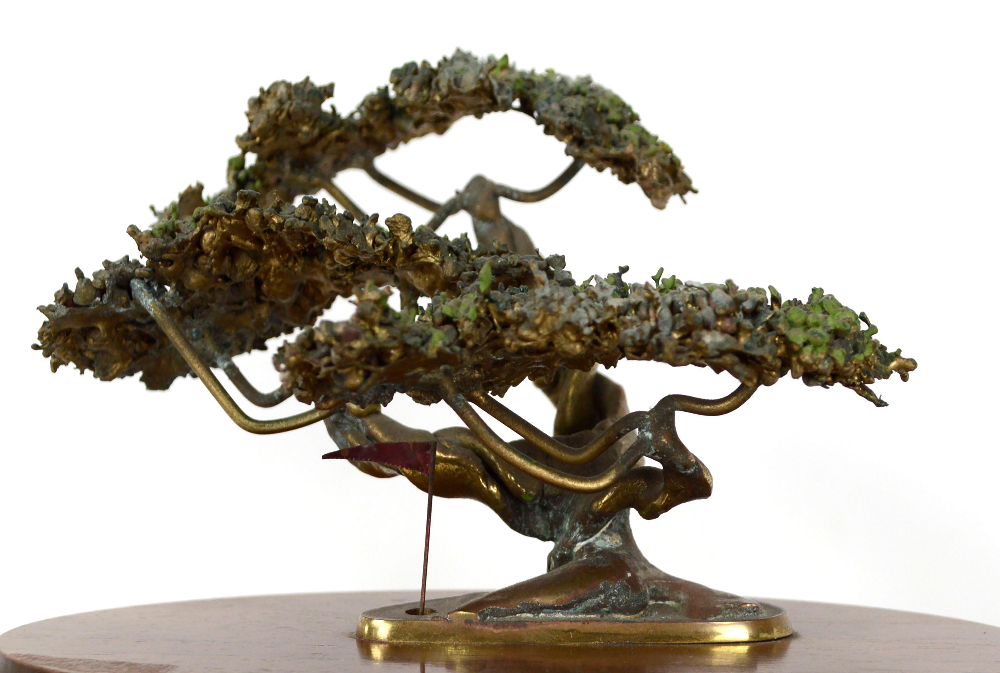 Beautiful small-scale bronze sculpture of a bonsai tree mounted on an oval wooden base by Robert Scott (American, 20th Century), with a small golf hole and red flag. The small tree is delicately detailed and its textured canopy of leaves is created