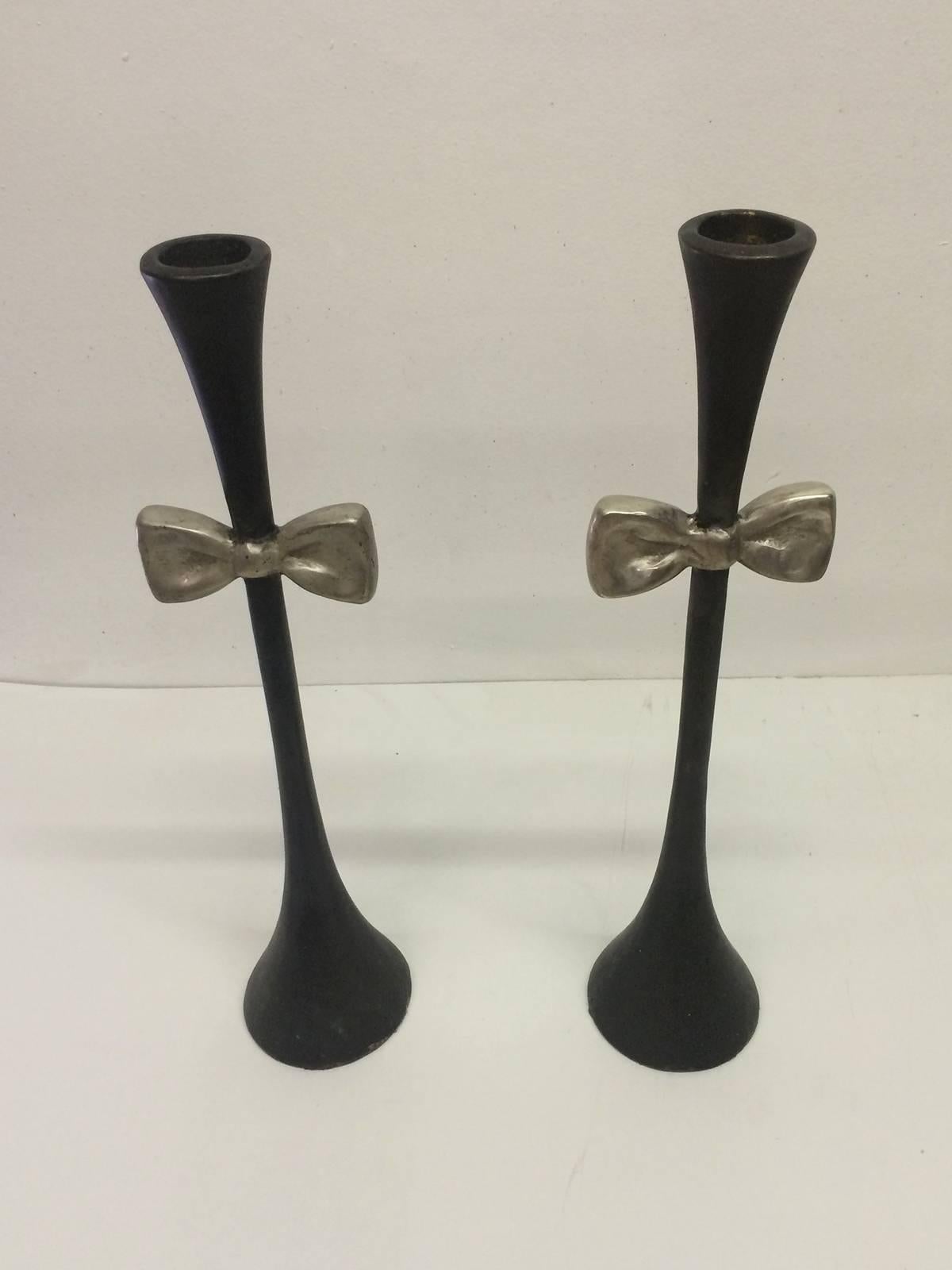 Pair of bronze candlesticks by Carl Gillberg. Conical ends and stem with a black finish and bow tie with a silver finish.
They are signed on the bottom.