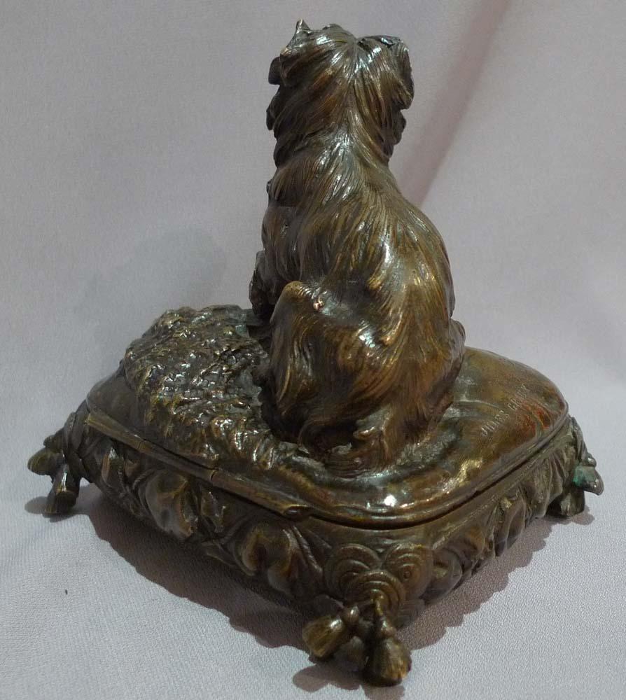 Ancien et très rare bronze animalier représentant un chien assis sur un coussin à glands. Le coussin est en fait une boîte et le coussin est articulé sur le côté. Excellente patine brun foncé et ensemble en excellent état. Le bronze est signé par P.