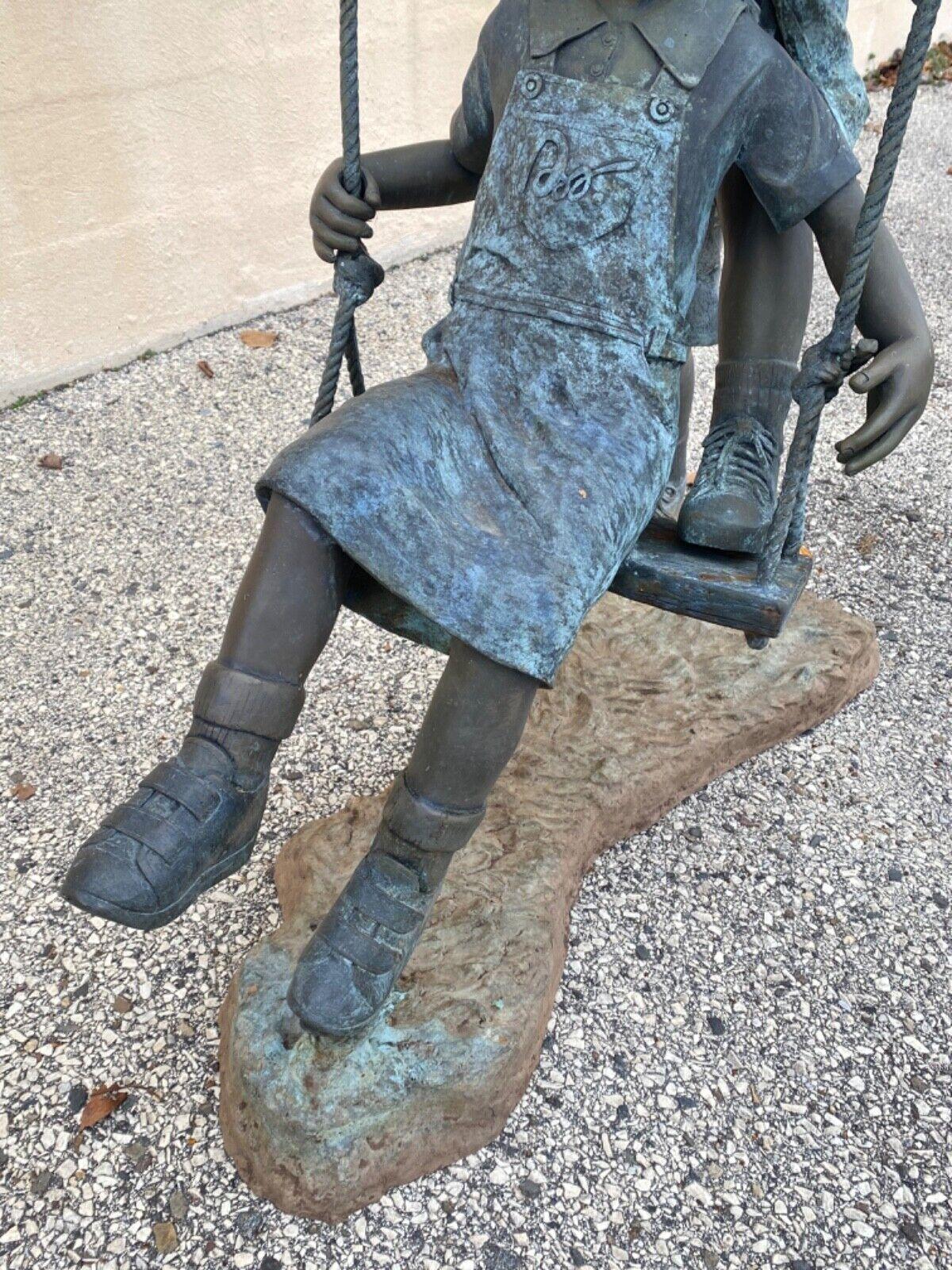 boy and girl on swing garden statue