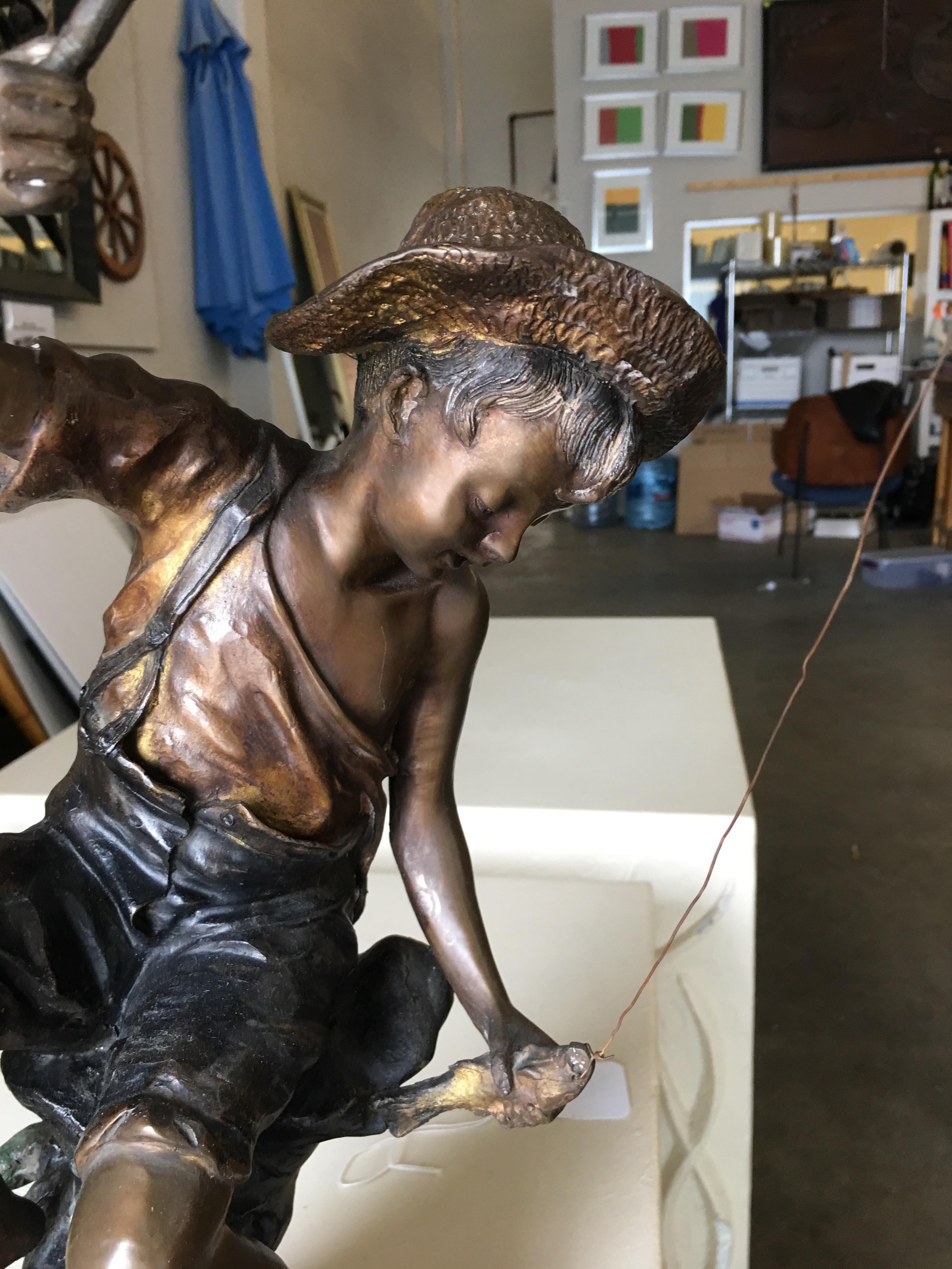 A young fisherman smiles down at his catch in this charming bronze figure by the famed Goldscheider of Vienna. This endearing piece is quintessential Goldscheider, epitomizing both the aesthetic appeal and naturalistic design of the Art Nouveau