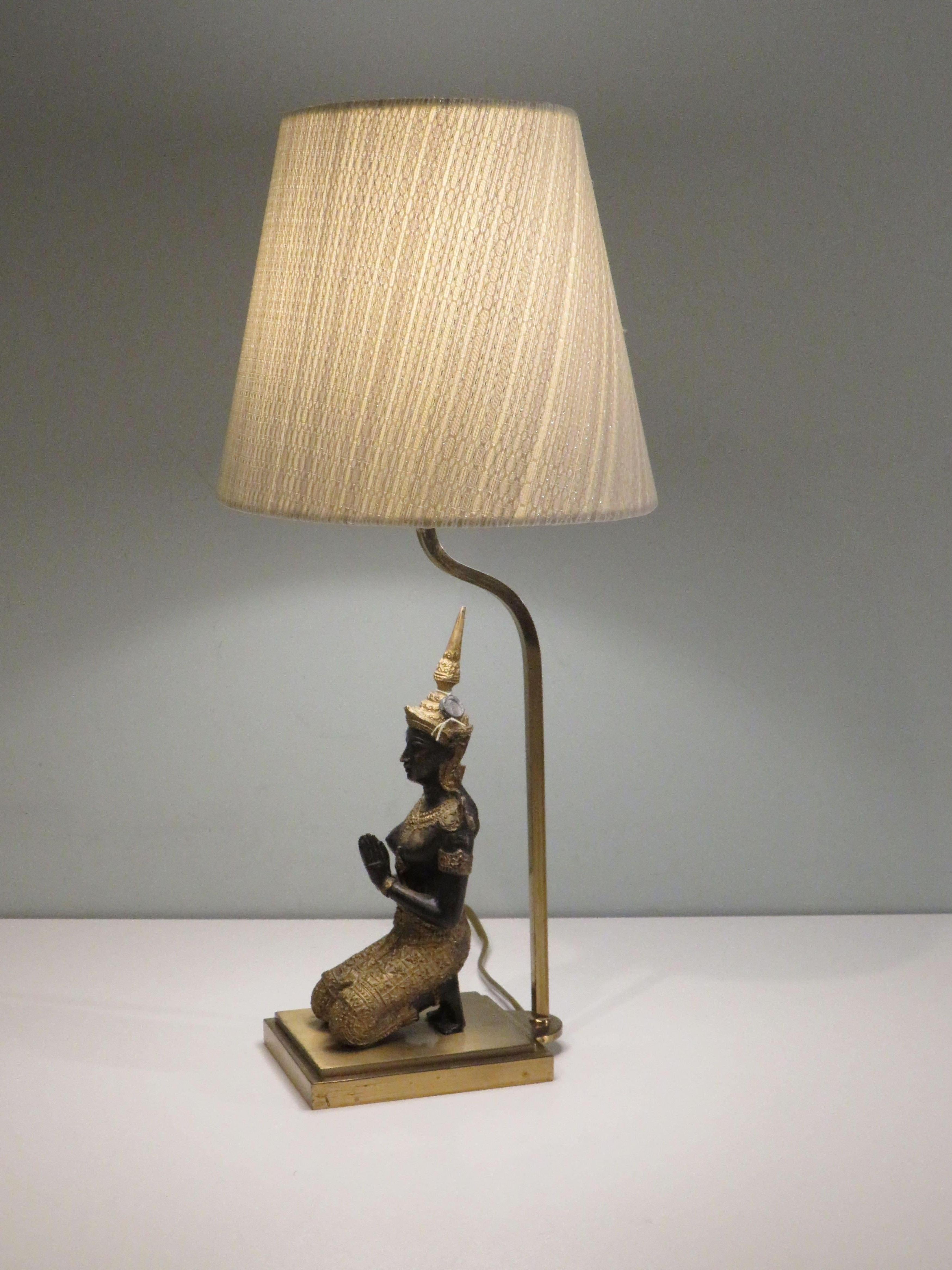 Elegant bronze Buddha on a brass base table lamp with a new custom-made, tapered oval lampshade in slightly shimmering ecru structure fabric.
The fixture is equipped with an E 27 lamp socket.
When delivered to the US, an adapter plug that conforms