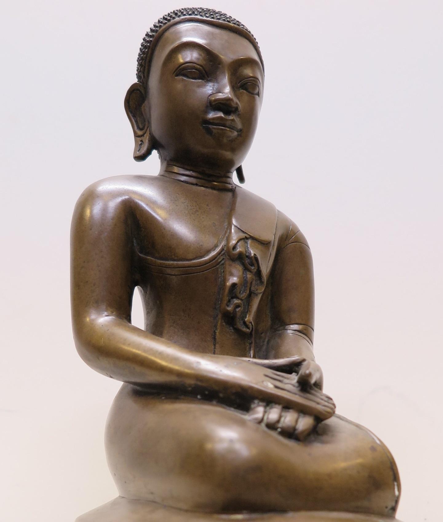 Bronze Burmese Buddhist statue lost wax casting Mandalay period (Burma) Myanmar. Beautiful example of Burmese Mandalay period bronze casting. Fluid graceful lines of the body outlining broad proud shoulders with robe draped to right perfectly