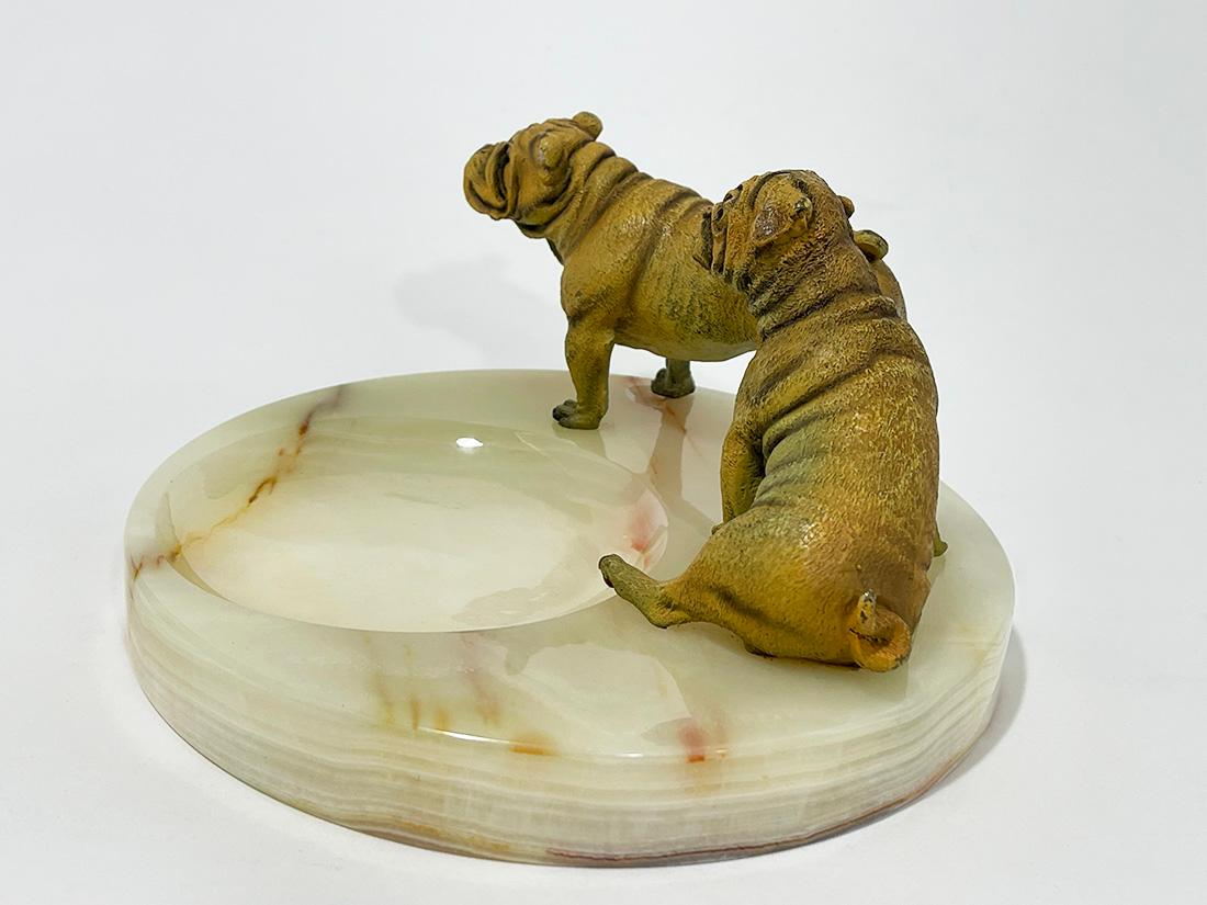 Bronze Bulldogs on an Onyx base by Vrai, France, 1920

Two large cold painted bronze Bulldogs (largest 14 cm long) standing and sitting on a Onyx base marked with Foundry mark Vrai Bronze (Vrai Bronze B.D., France, Paris) and dated MCMXX (1920)
A