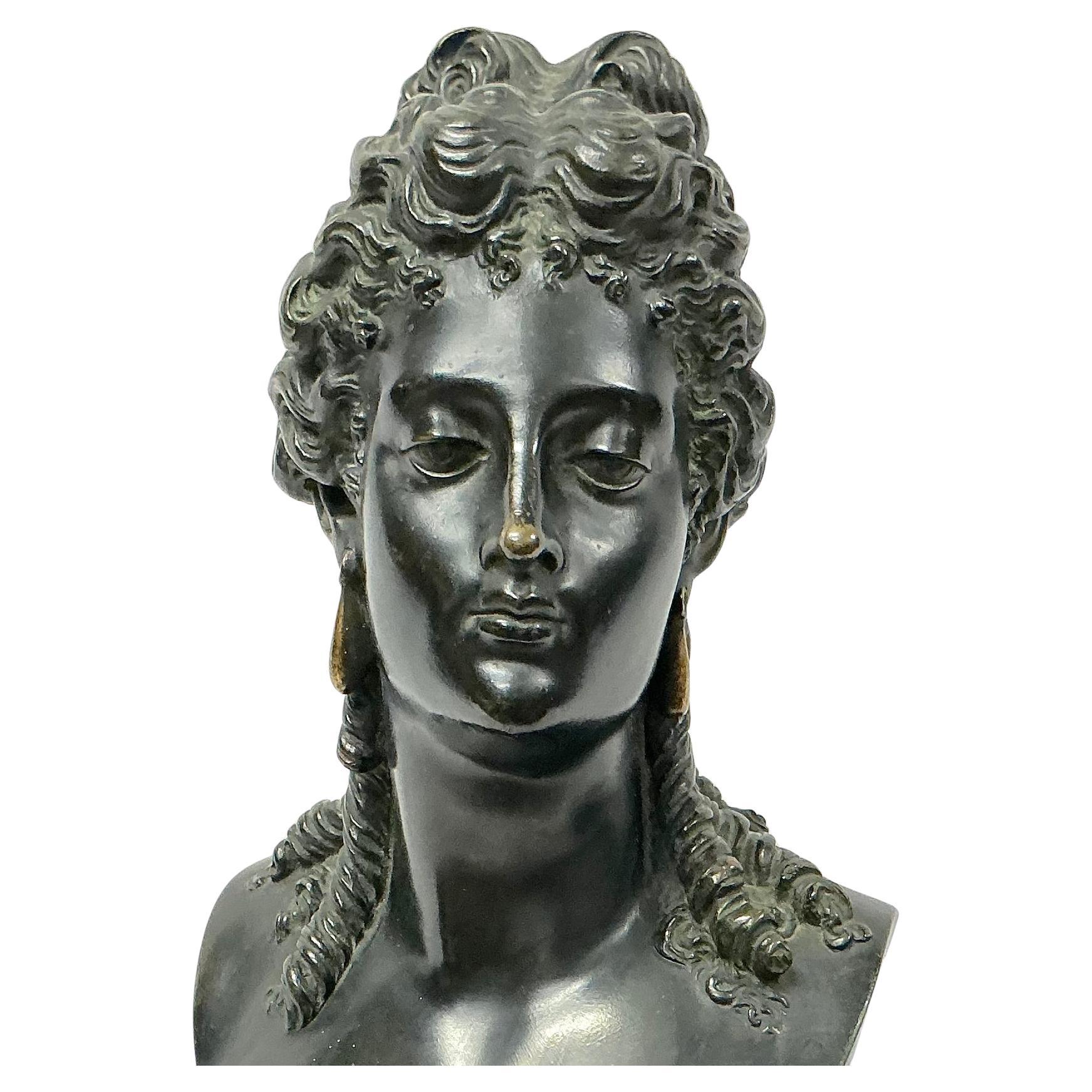 Buste en bronze patiné italien du XIXe siècle représentant une femme classique, probablement inspiré par les déesses ou les muses gréco-romaines. Le buste présente des boucles fluides finement détaillées et une expression élégante traduisant une