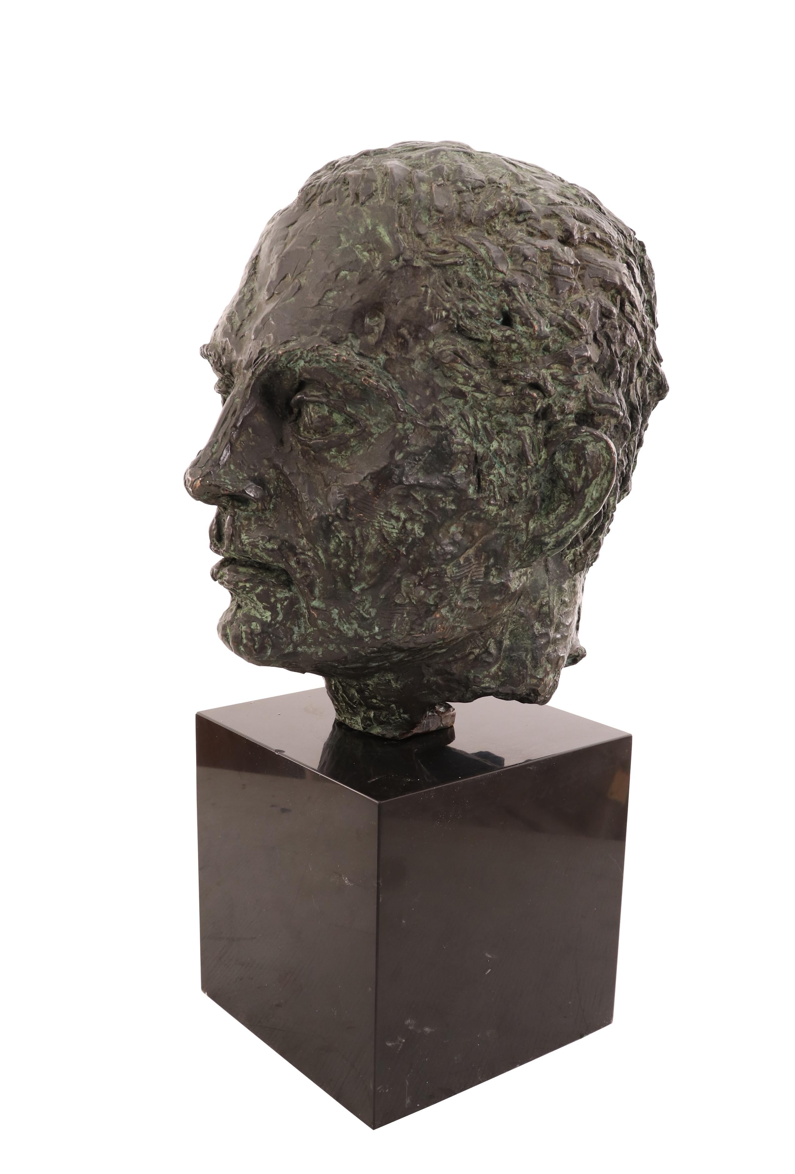 Mid-century bronze bust of a man's head mounted on a black marble cube base. (Signed 