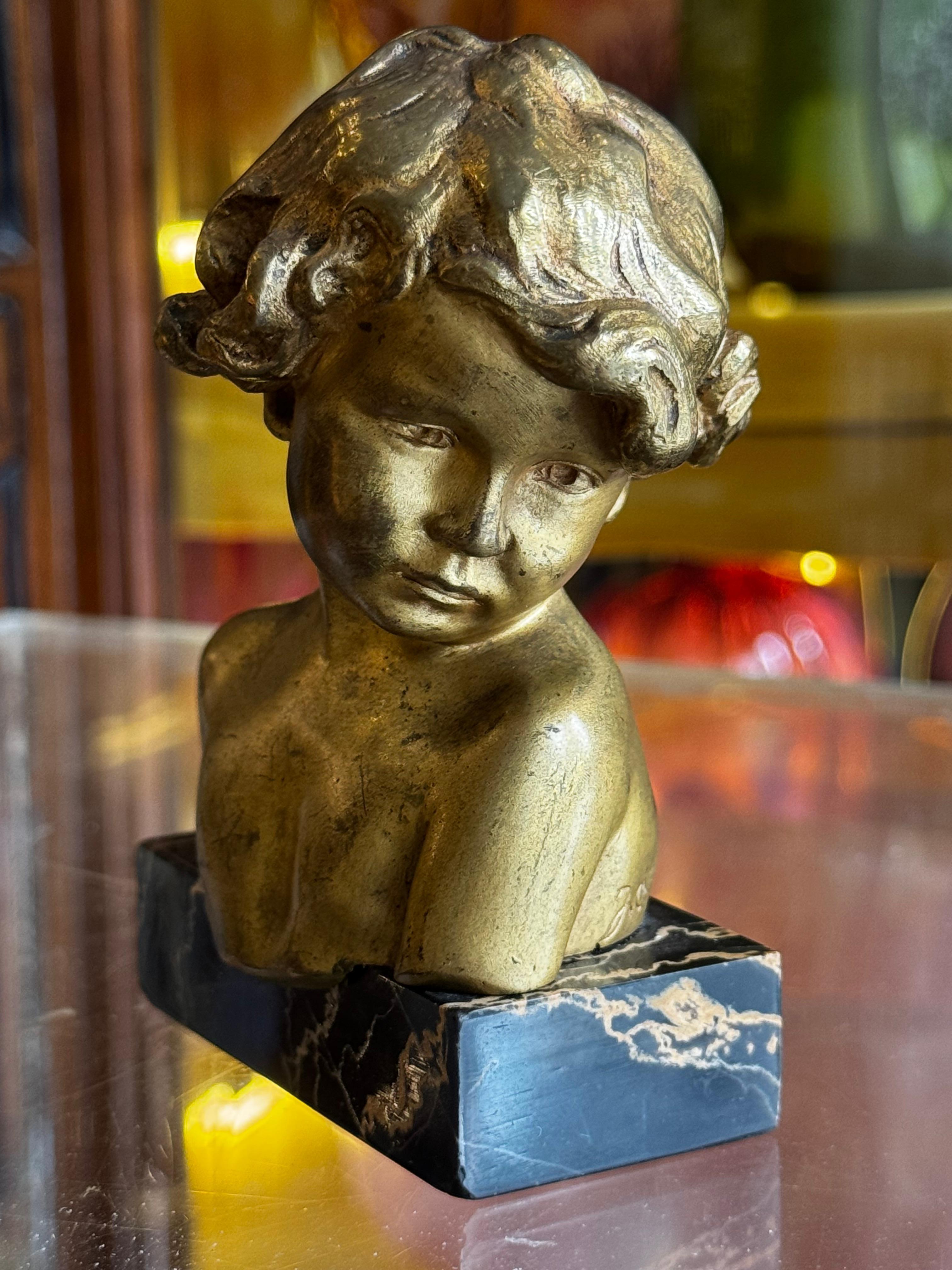 Splendido busto in bronzo di una giovane ragazza di Jean Camus, 1903. Questo squisito pezzo presenta un busto delicatamente scolpito di una giovane ragazza in bronzo dorato, che mette in mostra l'intricata maestria dell'artista e la sua attenzione