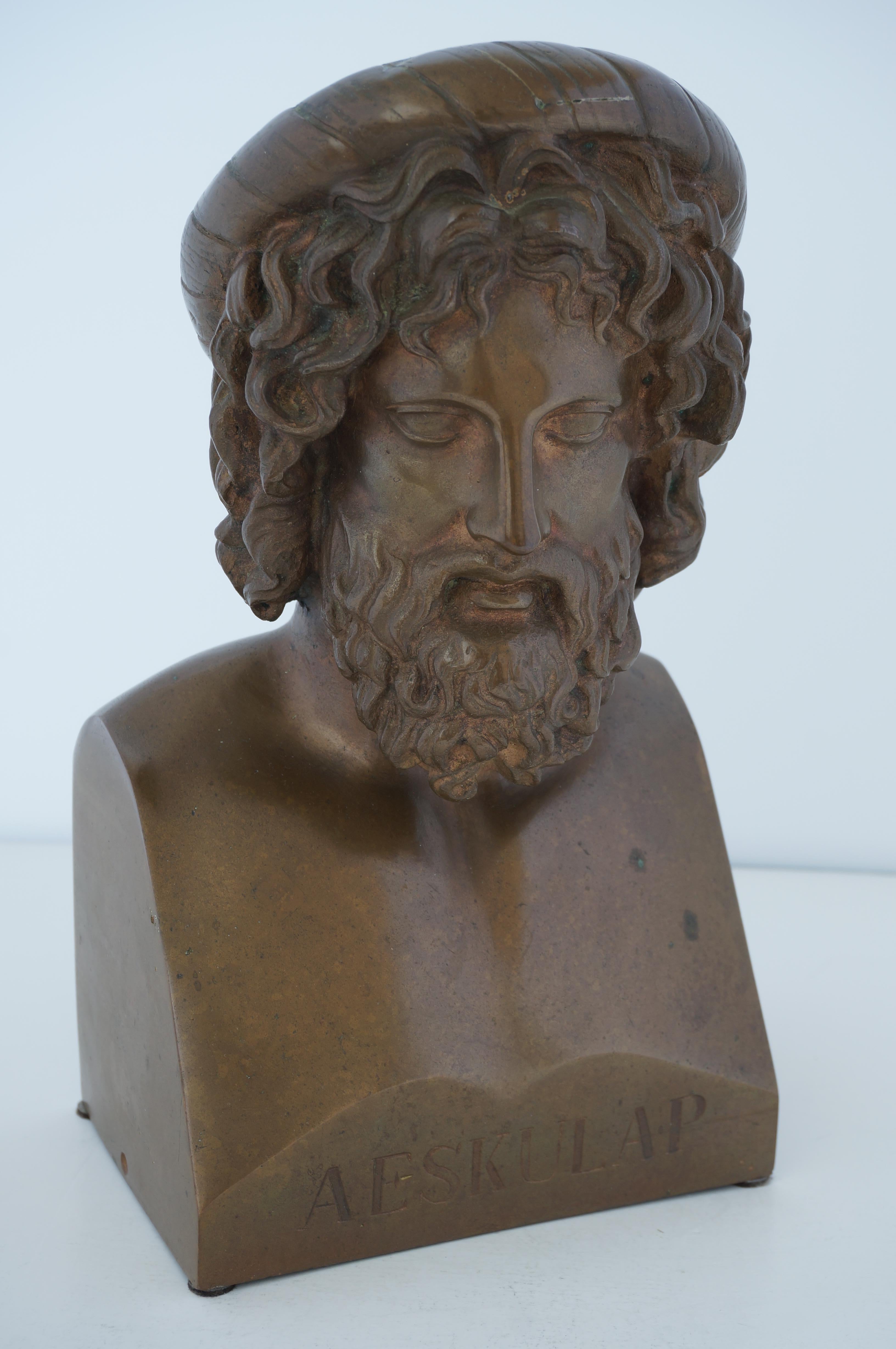 Cette sculpture en bronze stylisée du dieu grec oh guérisseur Aeskulap, a très probablement été acquise à l'origine lors du grand tour d'Europe à la fin du XIXe siècle. 

Remarque : le bord inférieur de chaque côté est percé d'un petit trou. Nous