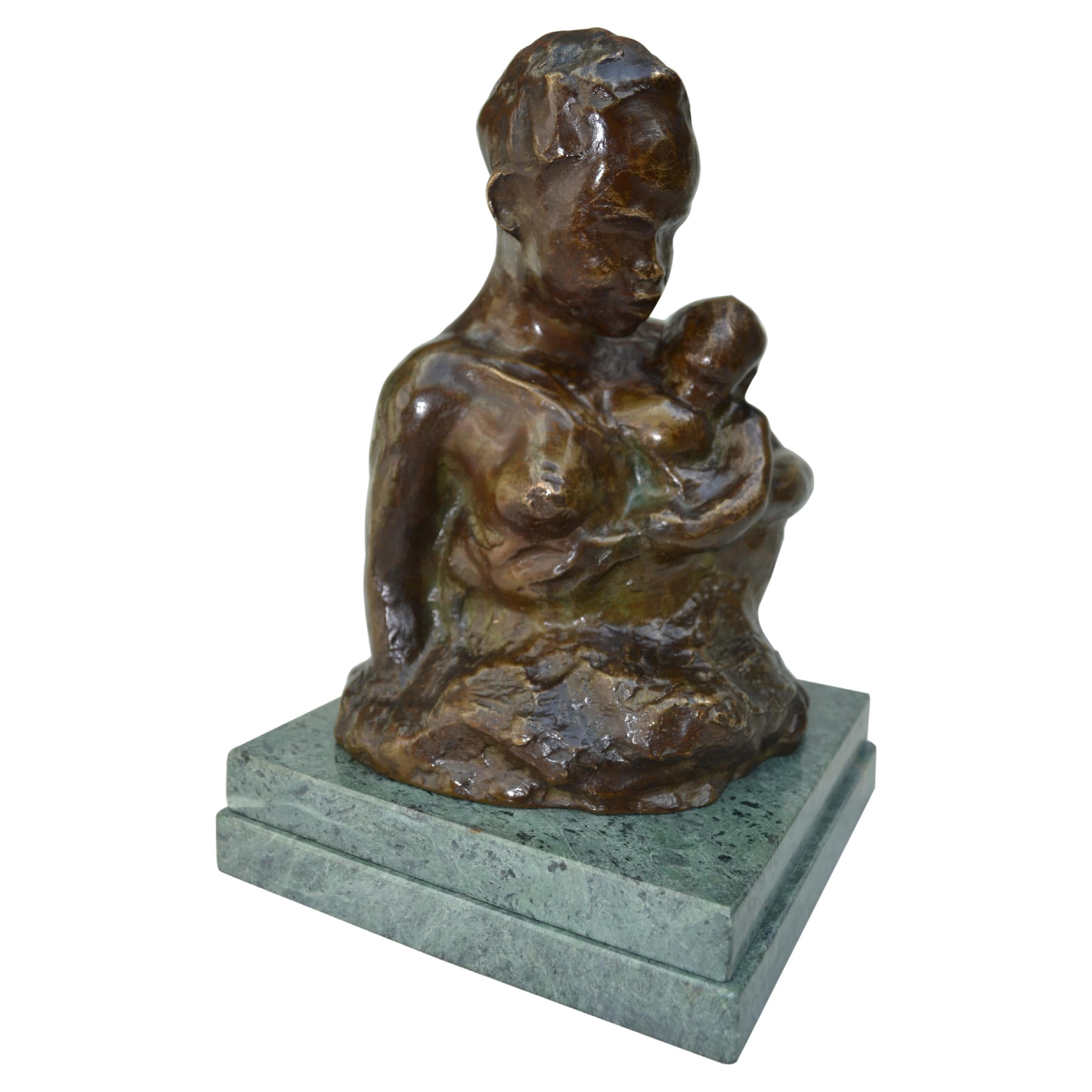 A beautifully cast Art Nouveau dark brown patinated bronze bust of a young African mother tenderly holding  and breastfeeding her baby.  The bronze is  signed Gardon an unlisted sculptor and  is reminiscent of a much more famous sculptor Auguste