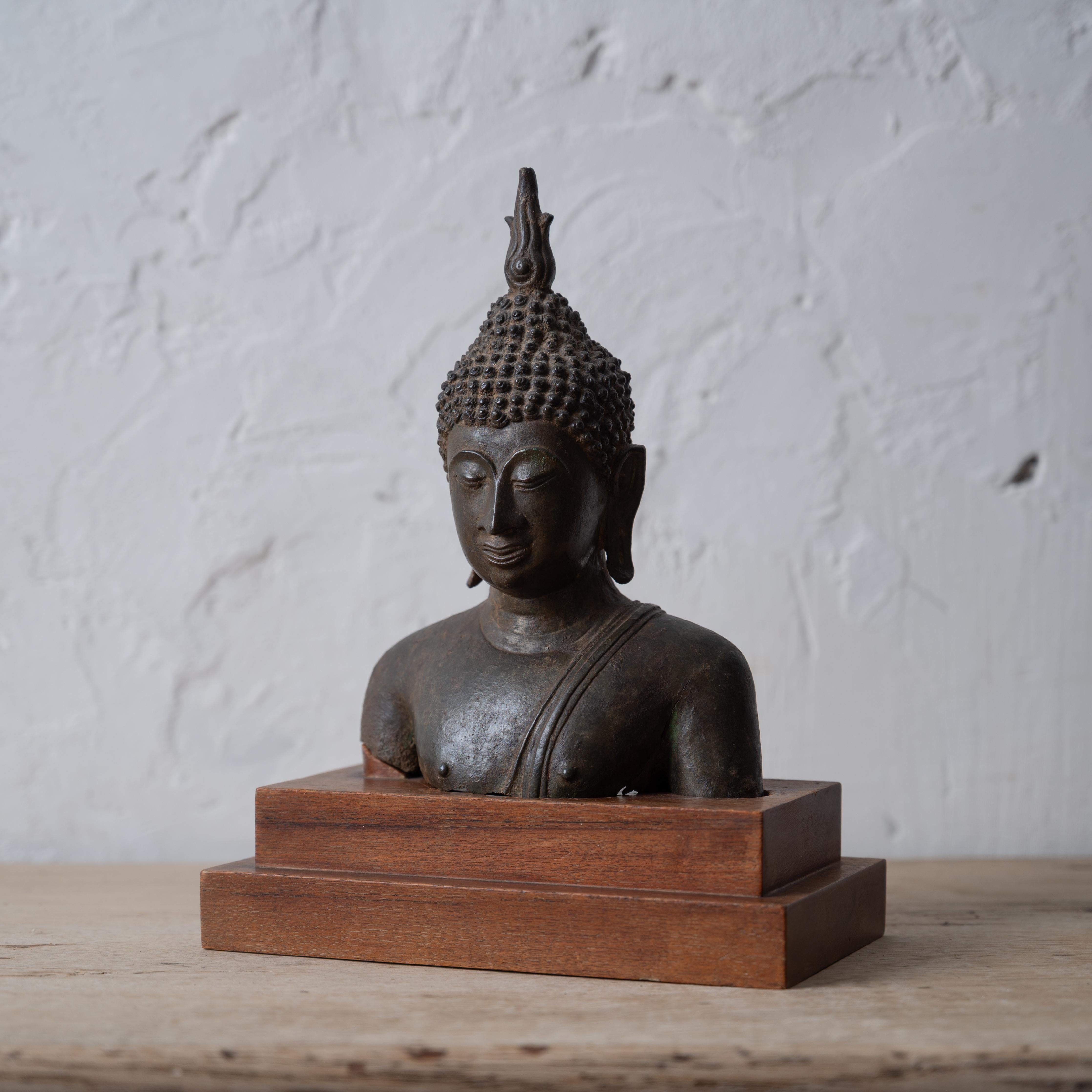 A fragment bronze bust of Buddha, Sukhothai style on custom base. 

Antique, pre-20th century. 



7 ⅞ inches wide by 4 ½ inches deep by 10 ¼ inches tall; 

bronze 5 ½ inches wide 3 ¼ inches deep by 8 inches tall





