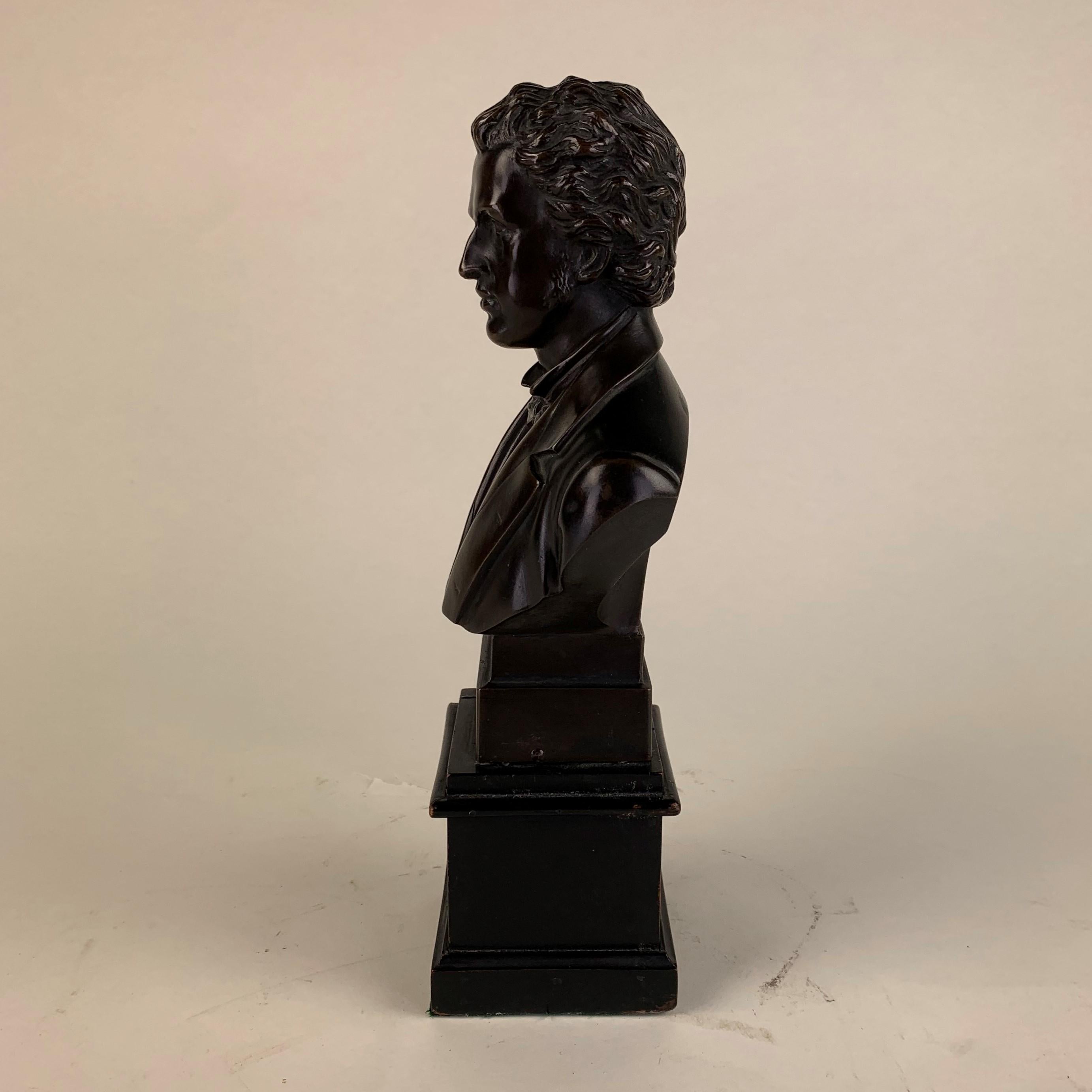 A good quality patinated bronze bust of Chopin rained on a square, stepped black wooden base. Well executed with good detail and rich brown patination.
Measures: (Base is 7cms by 7cms).