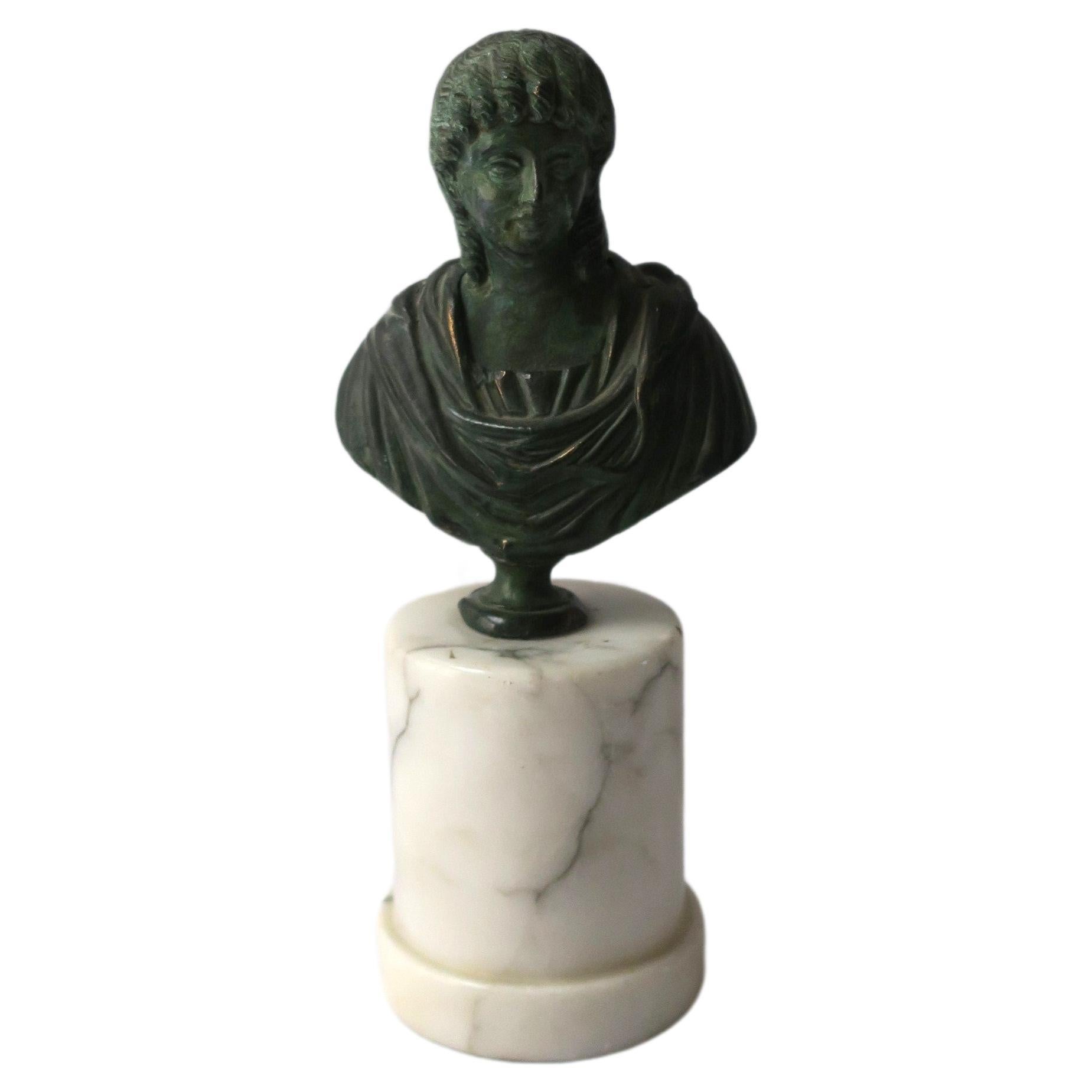 A substantial bronze bust on marble base, circa early-20th century, Europe. Bronze bust has a verdigris finish attached to a cylindrical Carrara marble column plinth base. A great decorative object for a table, shelf, library, etc. Dimensions: 7.75