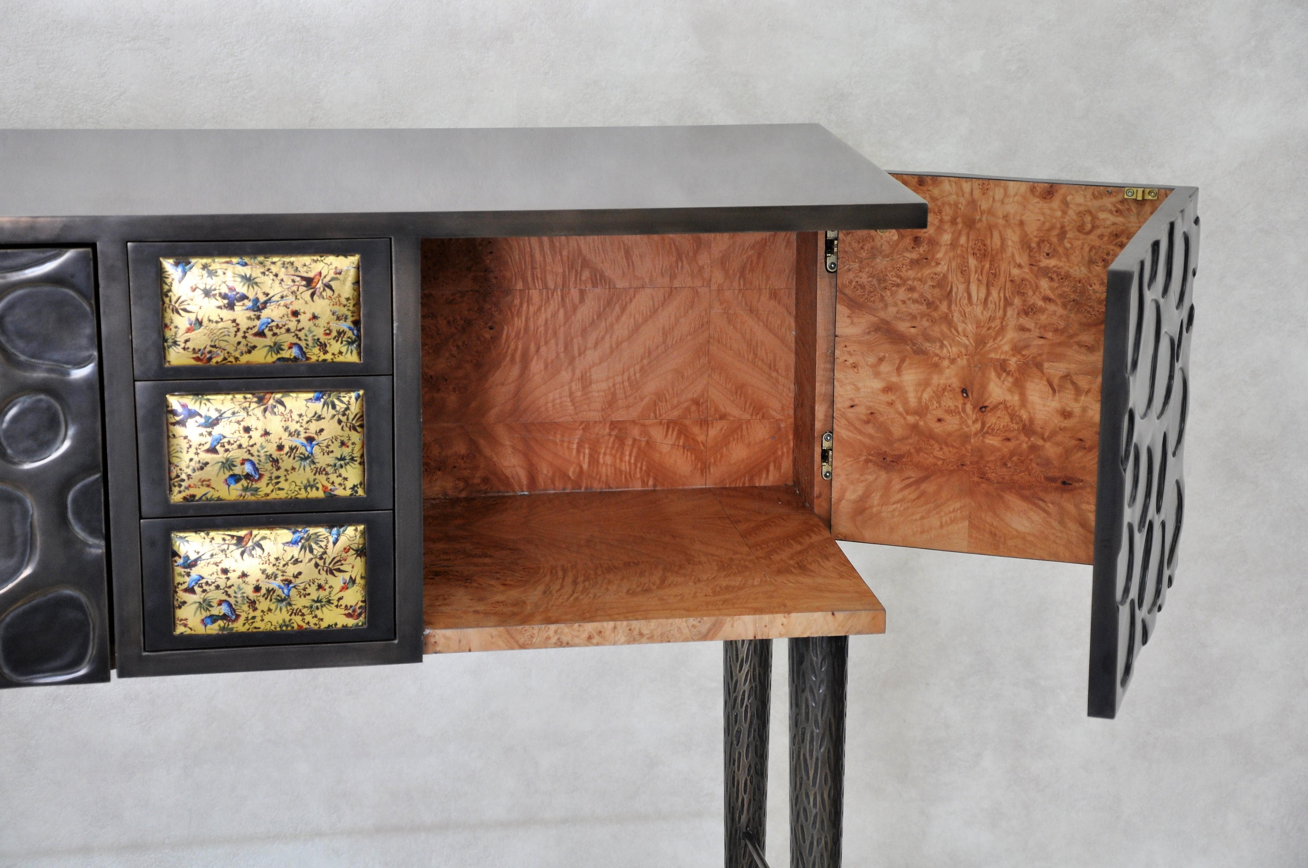 Burnished bronze over carved wood. Inside in polished maple burl veneer.
Drawer fronts covered with gilded leather.
Dimensions: H 105 x W 80 x D 40 cm. Edition of 3 (1 sold).
French contemporary artist and craftswoman Frédérique Domergue creates
