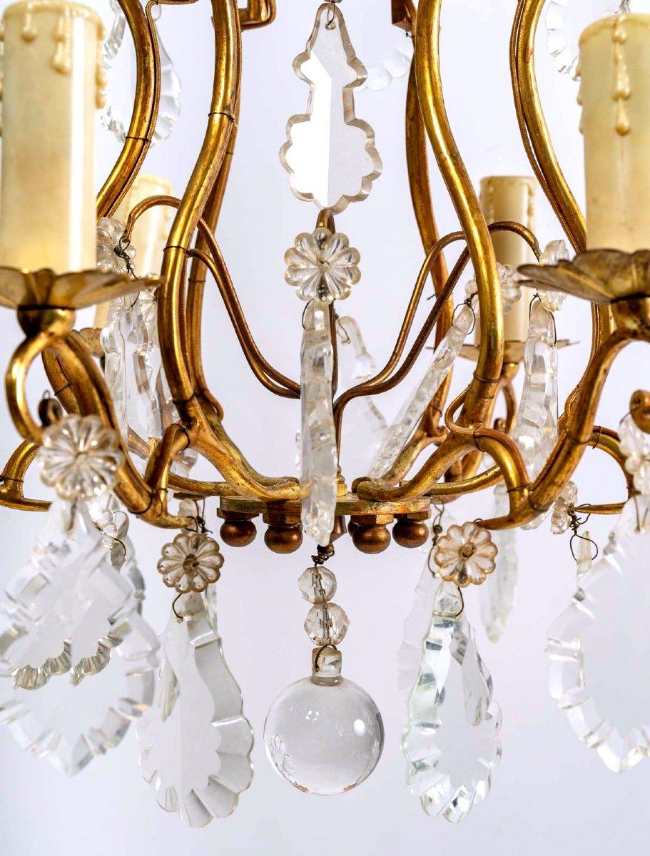 Lovely cage chandelier with six sconces, gilded bronze frame, cut crystal pendants.
Large tassels and daisy tassels magnify the light and refined frame of this piece with their luminous sparkles.

Period: 20th century
Style: Louis
