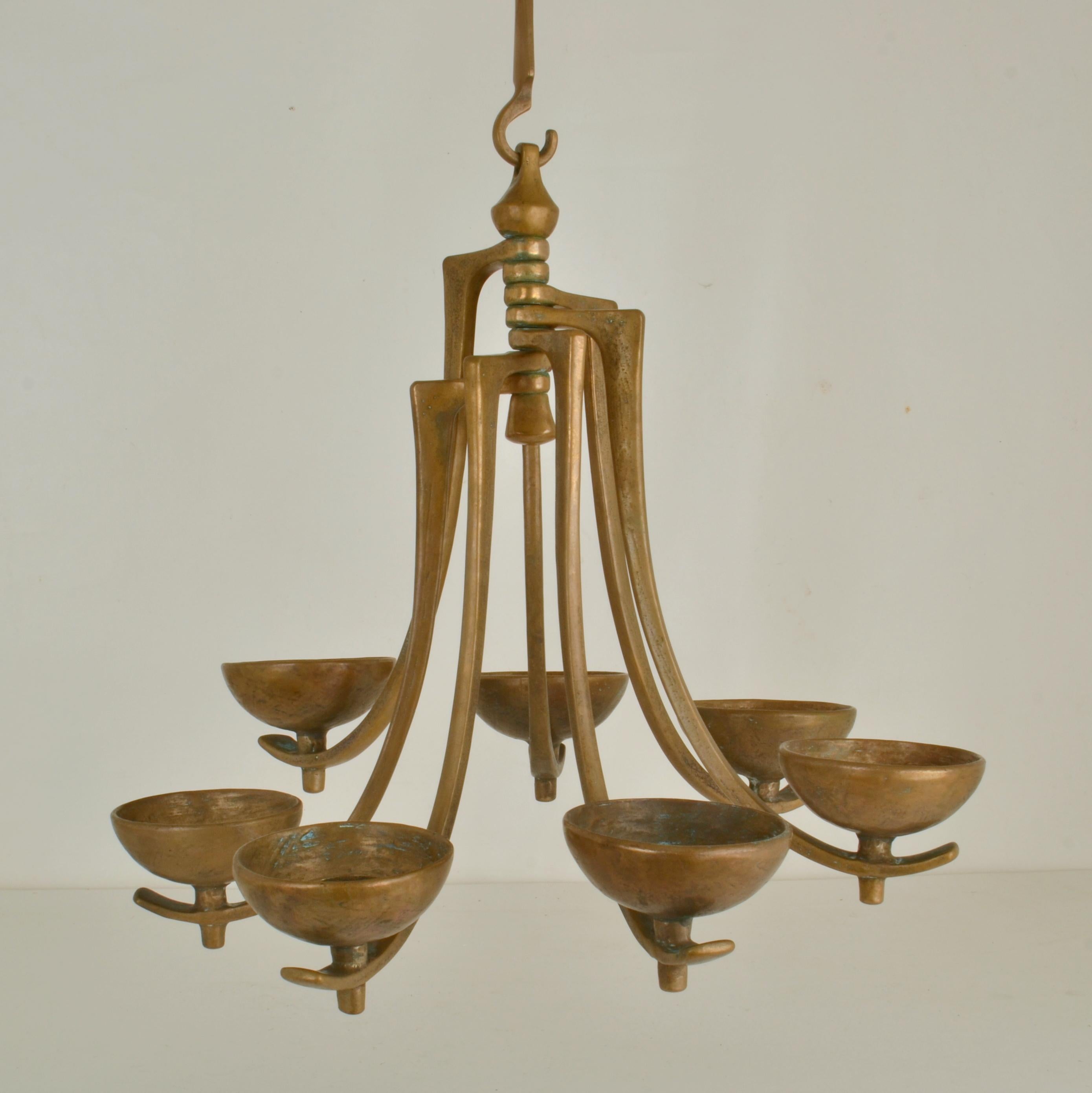 Bronze cast candelabra composed of seven radiating cast-bronze arms which hold a 5 cm diameter candle. It is designed by Michael Harjes and produced by Harjes Metalkunst in Germany. The candle holder is in excellent condition with a beautiful deep
