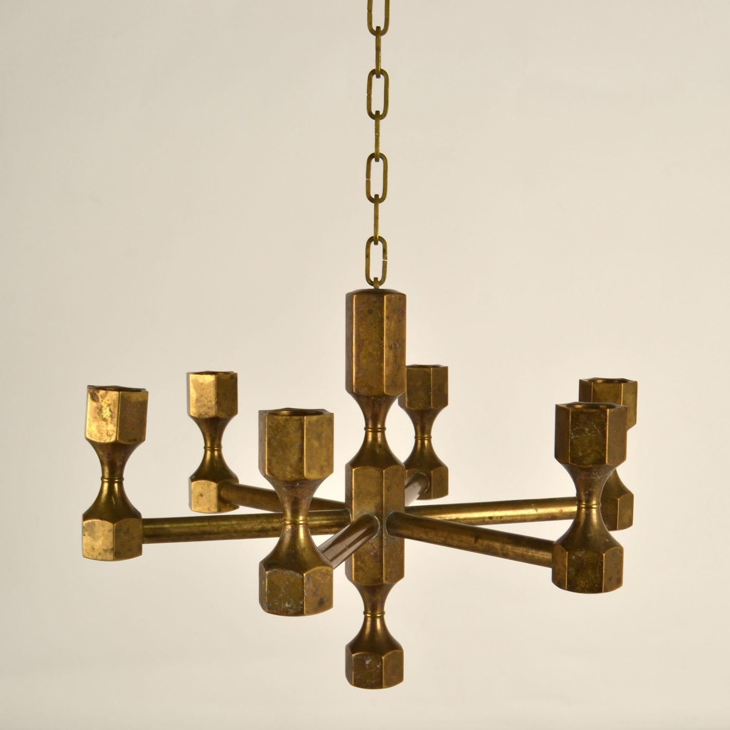 Bronze cast candelabra pendant composed of six cast arms candle holder for regular candles hanging from a chain. It is designed in the style of Michael Harjes Metalkunst, Germany 1960's. The candelabra is a 20th century modern update of bronze