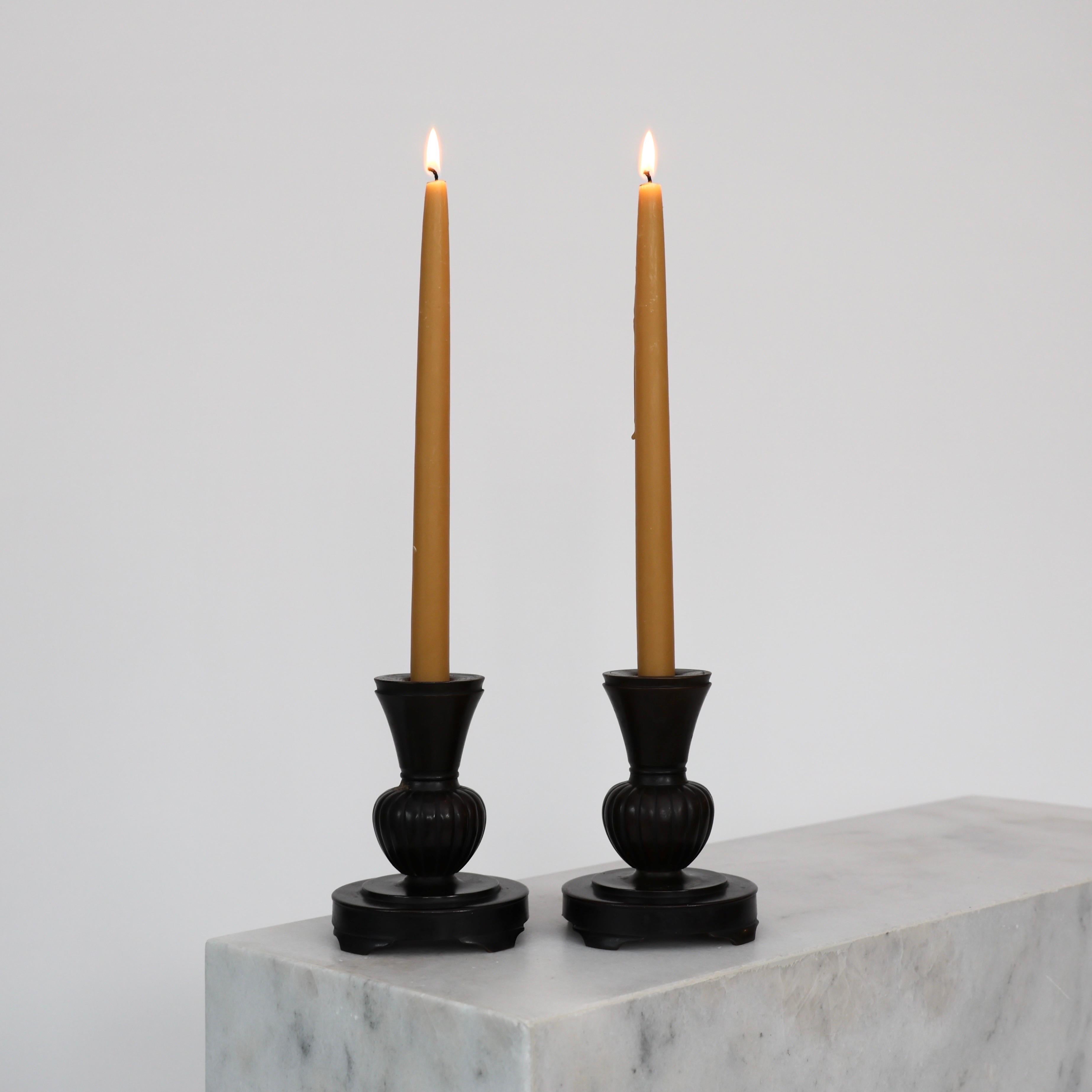 Substantial Bronze Candleholders made by Just Andersen in the 1920s. A rare set for an exquisite home.

* Pair (2) of Bronze Candlestick Holders 
* Manufacturer: Just Andersen
* Style: B119
* Year: 1925-1930
* Condition: Good vintage condition.