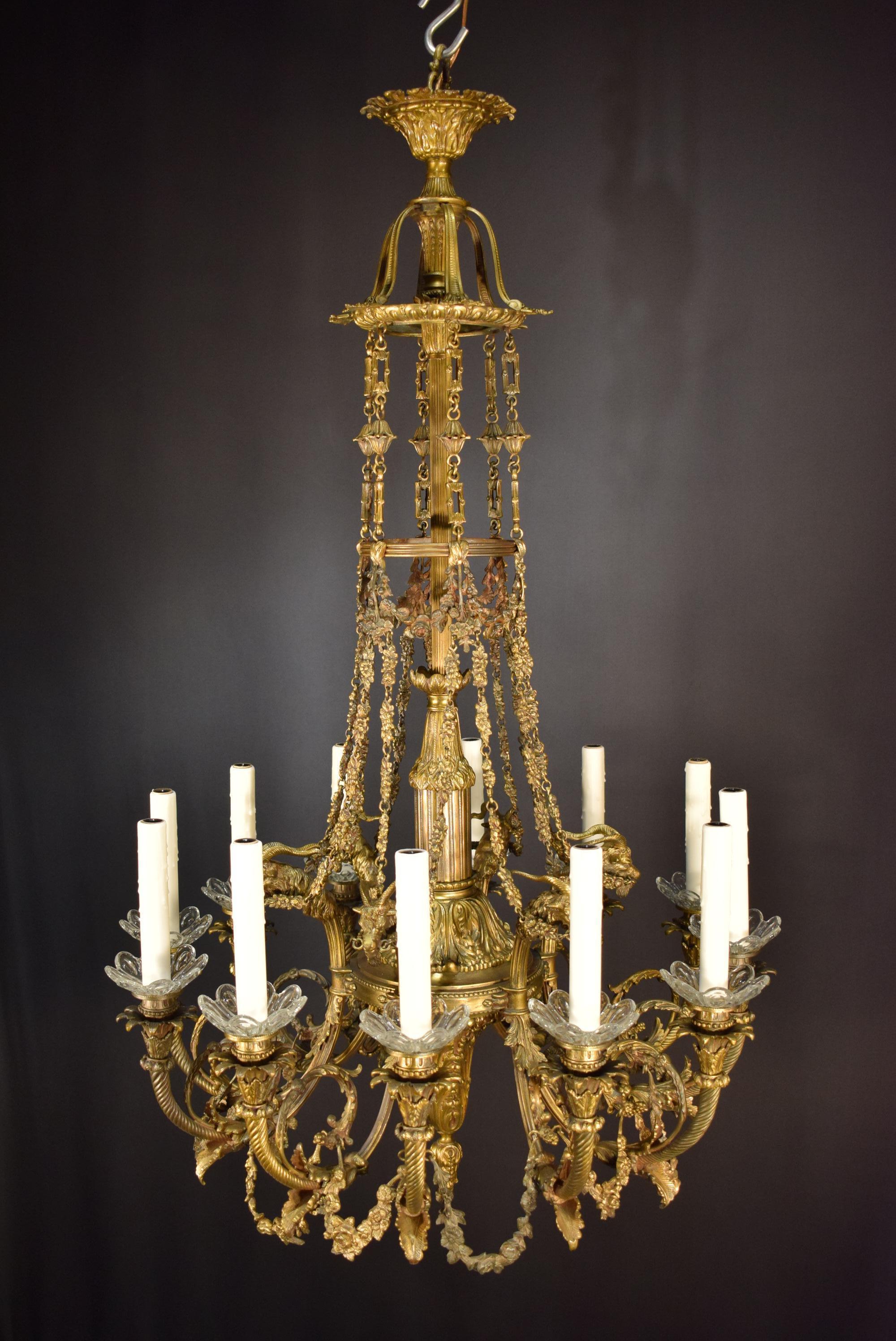 A very fine gilt bronze chandelier depicting ram's heads stylized flower garlands, exquisite decorative chains. Crystal bobeches.
France, circa 1900. 12 lights.
Dimensions: Height 43 1/2