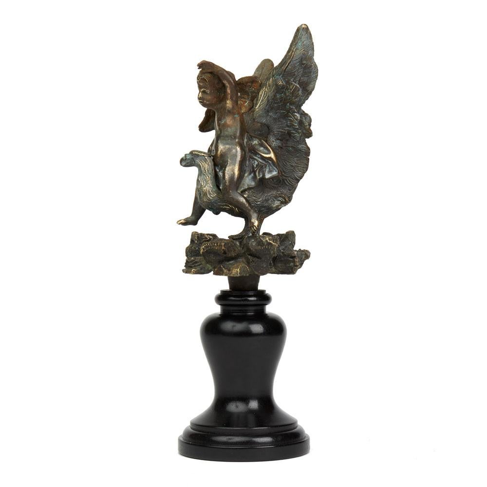 A very rare antique bronze fountain fitting mounted on a later purpose made wooden base with a detachable winged cherub seated on the back of a vulture like bird with its wings raised ready for flight and standing on a simulated rock work base. This