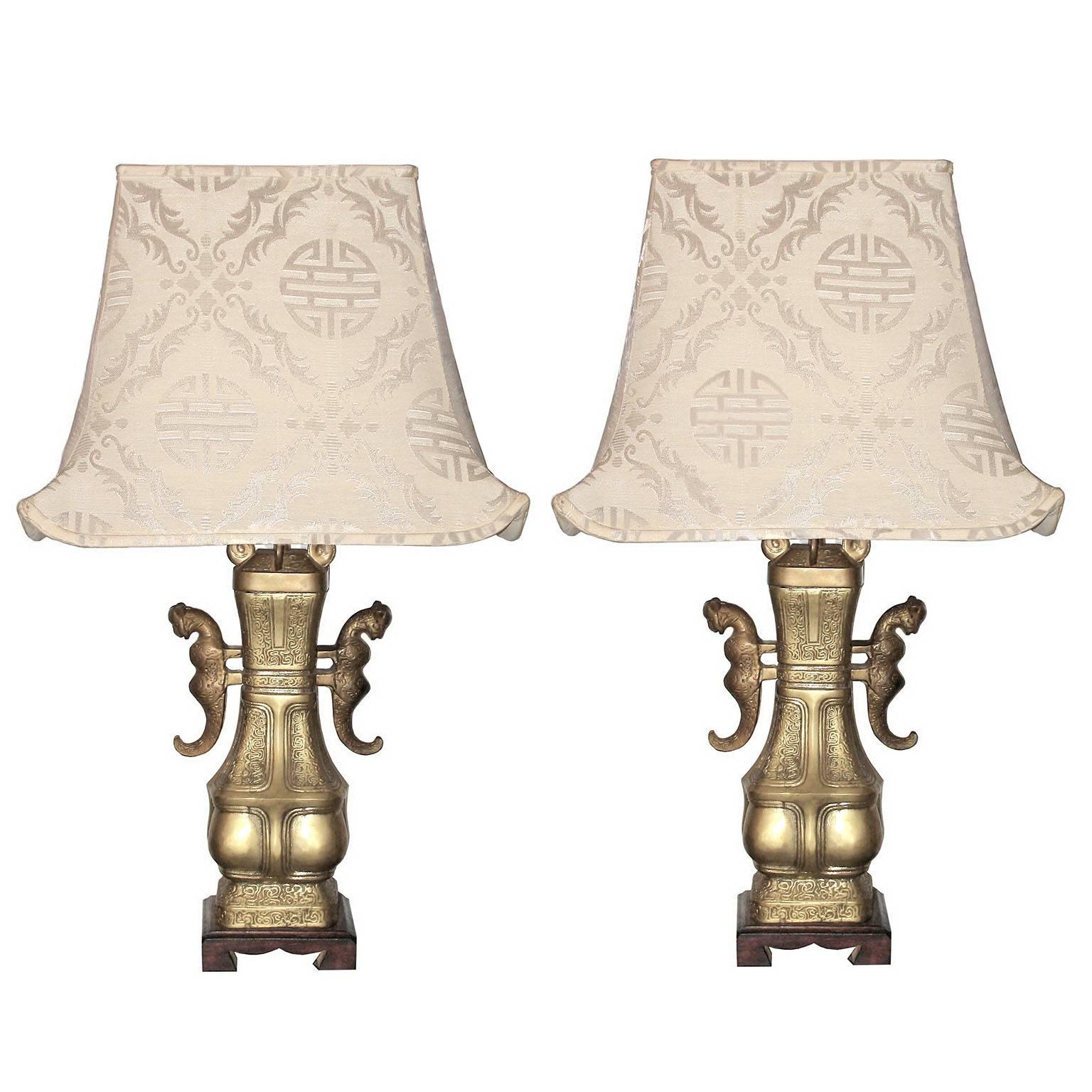 Bronze Chinese table lamps with silk pagoda shades

Pair of large bronze table lamps with feline decor handles. Wooden foot, silk fabric screens in pagoda form, first half of the 20th century sec.
Dimensions:
Height 73 cm (28.74 in.), width 43