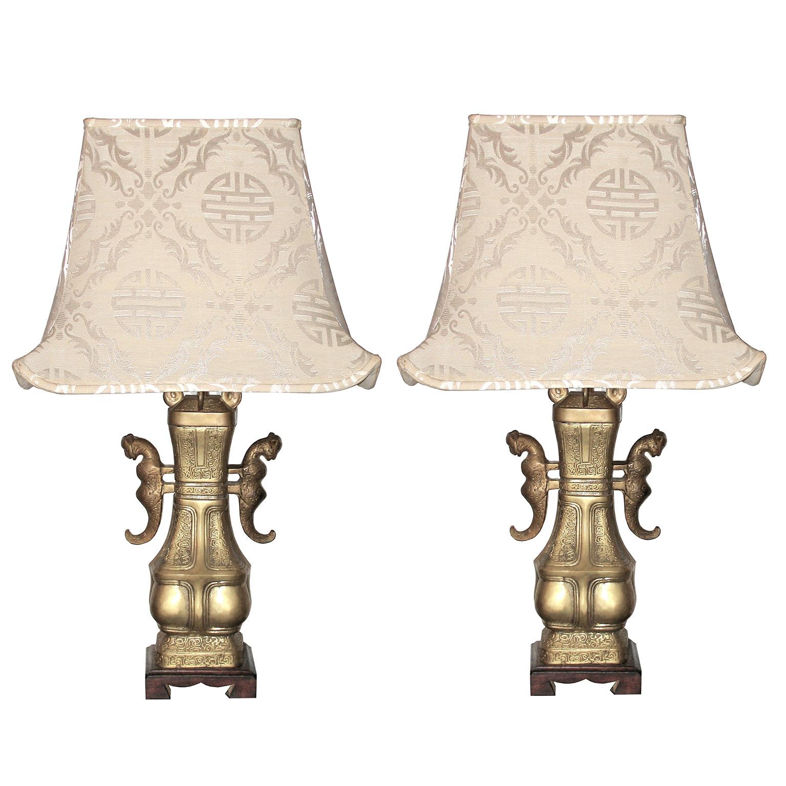 Lampade da tavolo cinesi in bronzo con paralumi a pagoda in seta

Coppia di grandi lampade da tavolo in bronzo con maniglie a decoro felino. Piede in legno, paraventi in tessuto di seta a forma di pagoda, prima metà del XX secolo