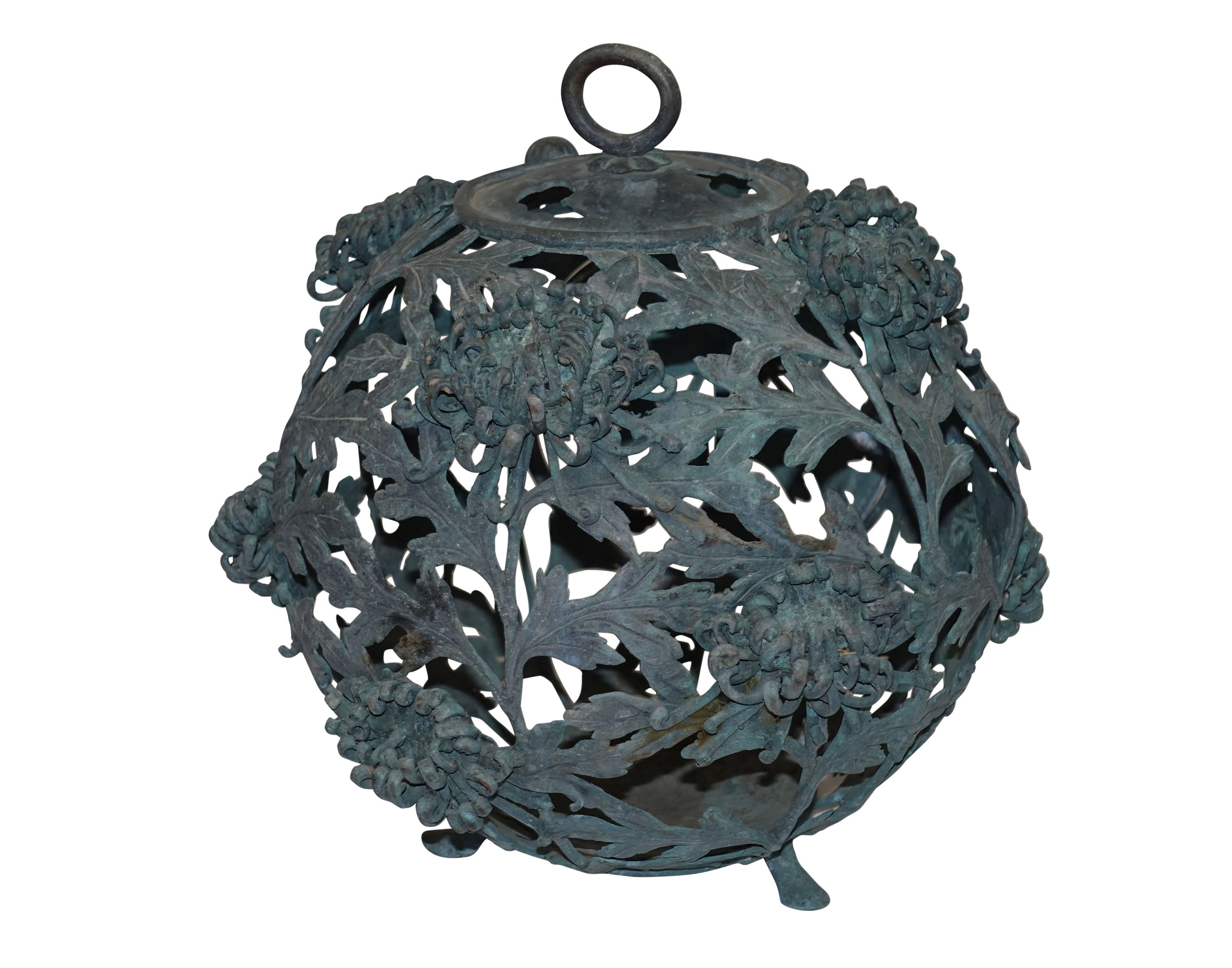 Wonderfully unique bronze hanging garden lantern in spherical shape with blooming chrysanthemum flowers, ring handle for hanging, and sitting on pad feet. Has a charming chrysanthemum bud knob for opening the cage door. Signed by artist on the