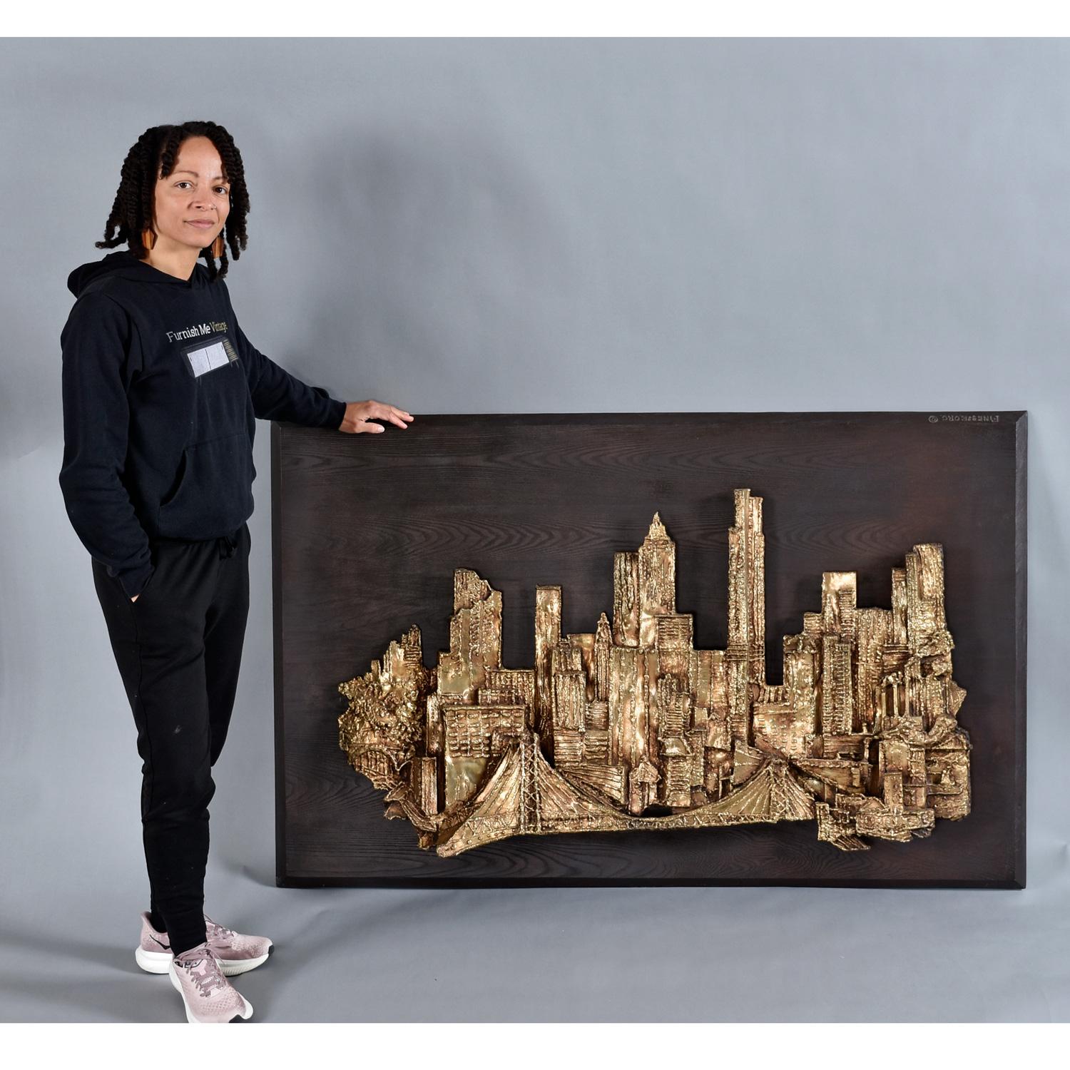 Impressionnante sculpture murale tridimensionnelle Brutalist de 5 pieds x large, suspendue au mur par Finesse Originals. Le paysage urbain est composé de fibre de verre qui donne l'effet d'une sculpture en or ou en bronze. L'architecture en fibre de