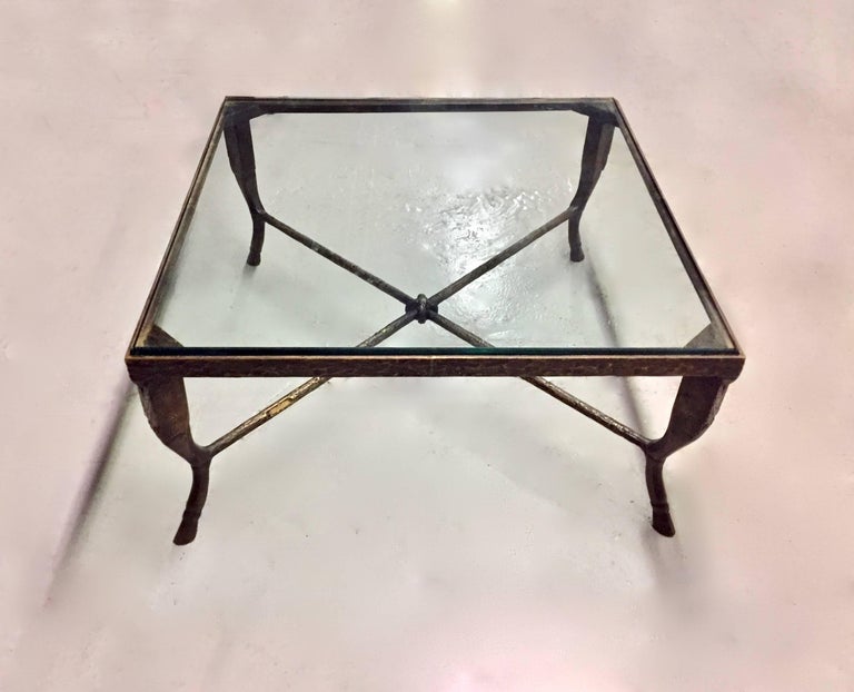Bronze coffee table by designer Christopher Chodoff with original patina and strewed bronze texturing throughout. The table has an x-shaped stretcher with a decorative link-shaped  detail; the base supports a 3/4