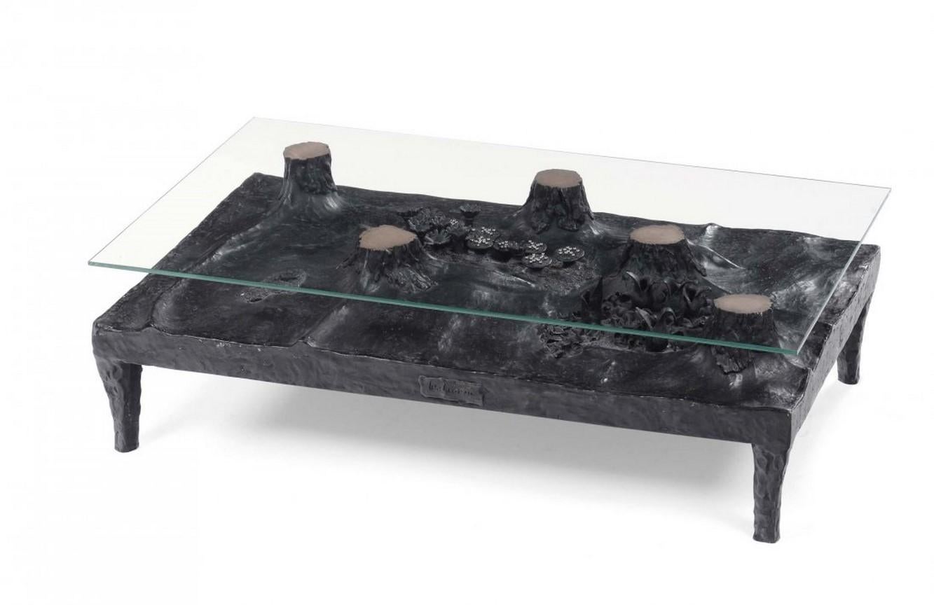 Patinated bronze coffee table by Leo Lionni, with crystal glass top. The hammered bronze base depicts a naturalistic scene. Signed. A unique piece.