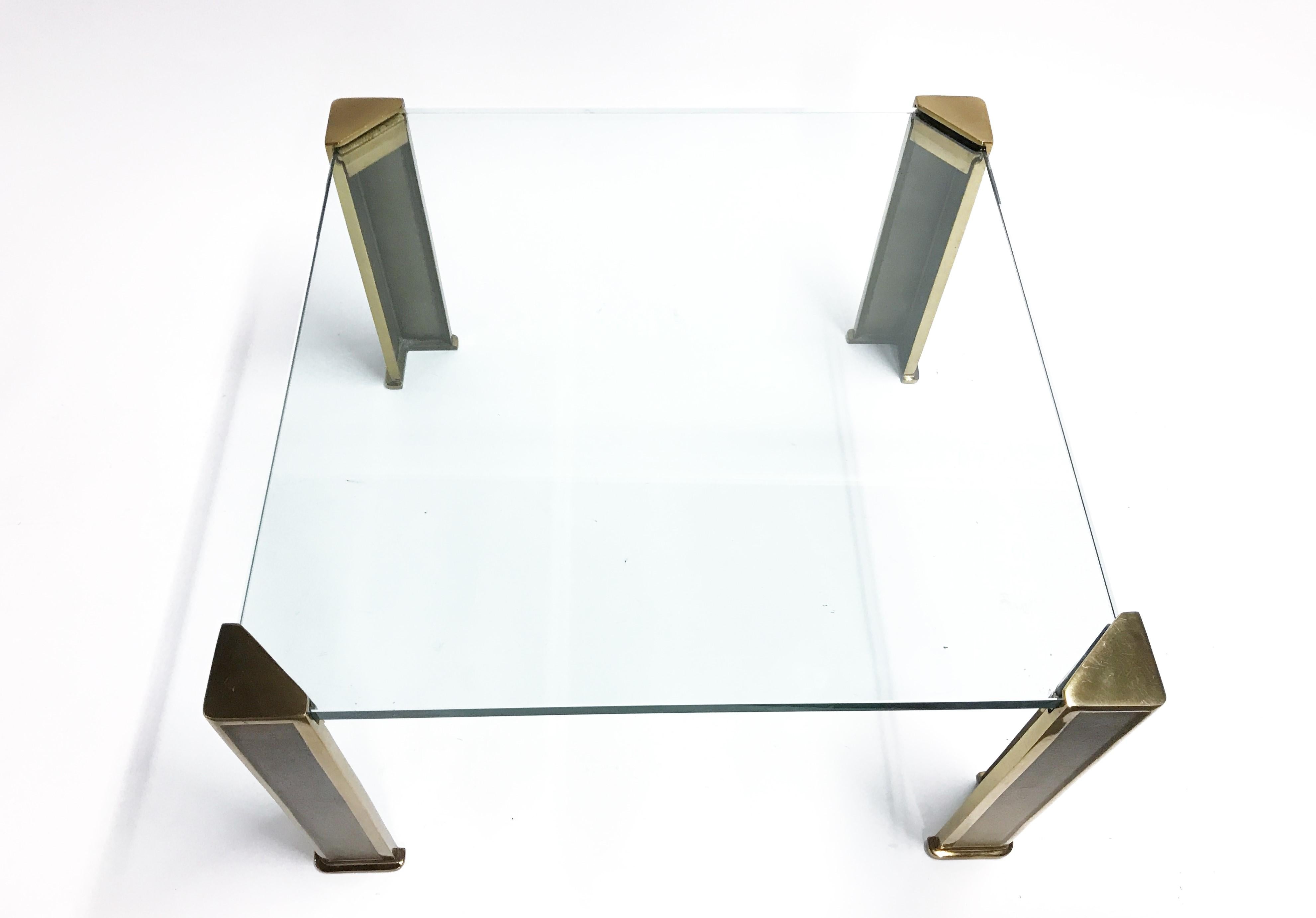 Square glass coffee table with cast bronze legs design by Peter Ghyczy.

The thick glass top is supported in the corners by the heavy bronze legs so it looks to be floating.

Thick 15 mm clear glass tabletop.

1970s, Germany

Measures: