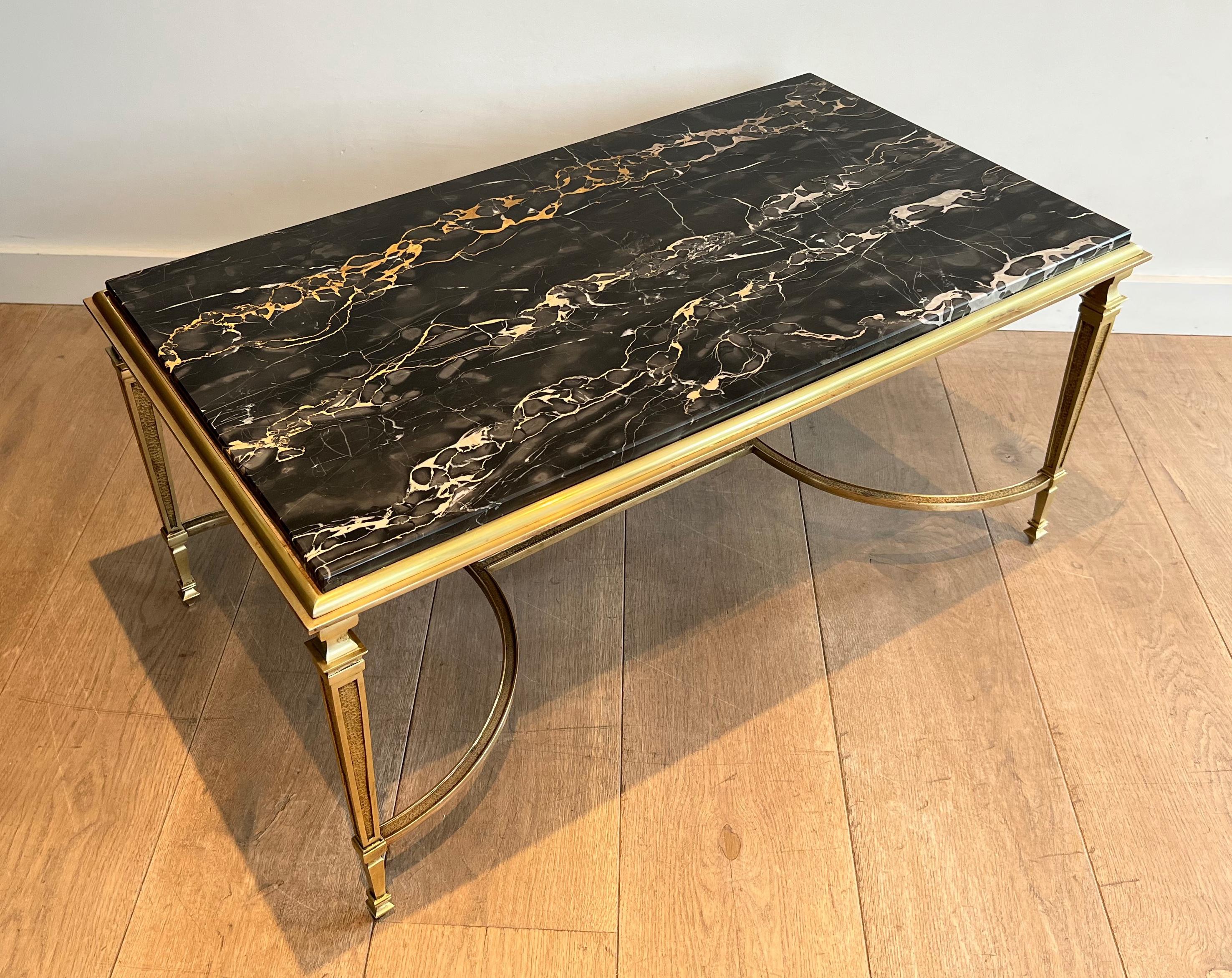 This coffee table is made of bronze with a black Portor marble top. This is a French work in the style of Maison Jansen. Circa 1940