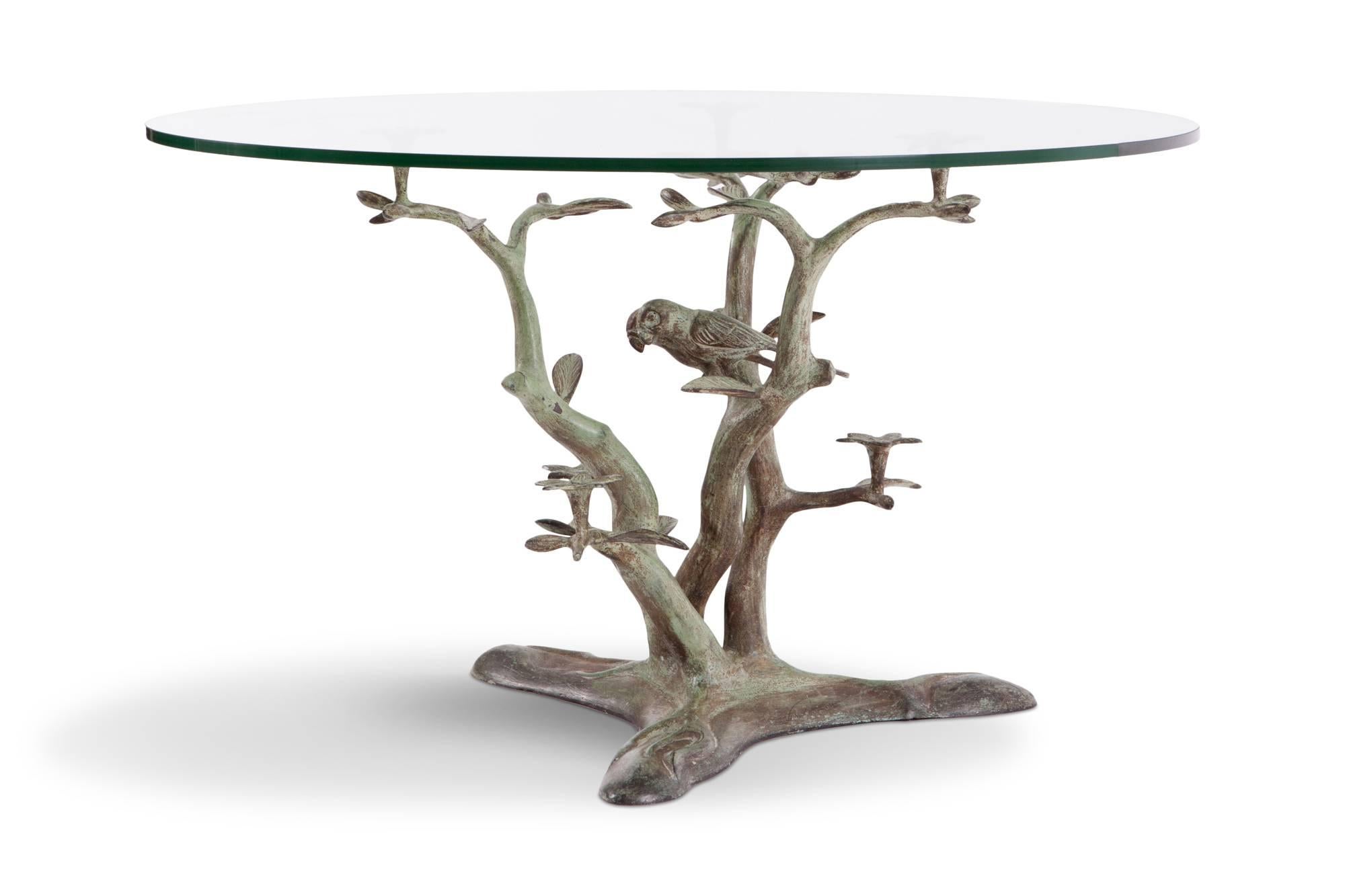 Hollywood regency decorative patinated bronze coffee table with round glass table top. The table displays several branches with leafs and flowers and in the centre a couple of parrots. The bronze base has a nice green color patina.

Measures: Ø 80 H