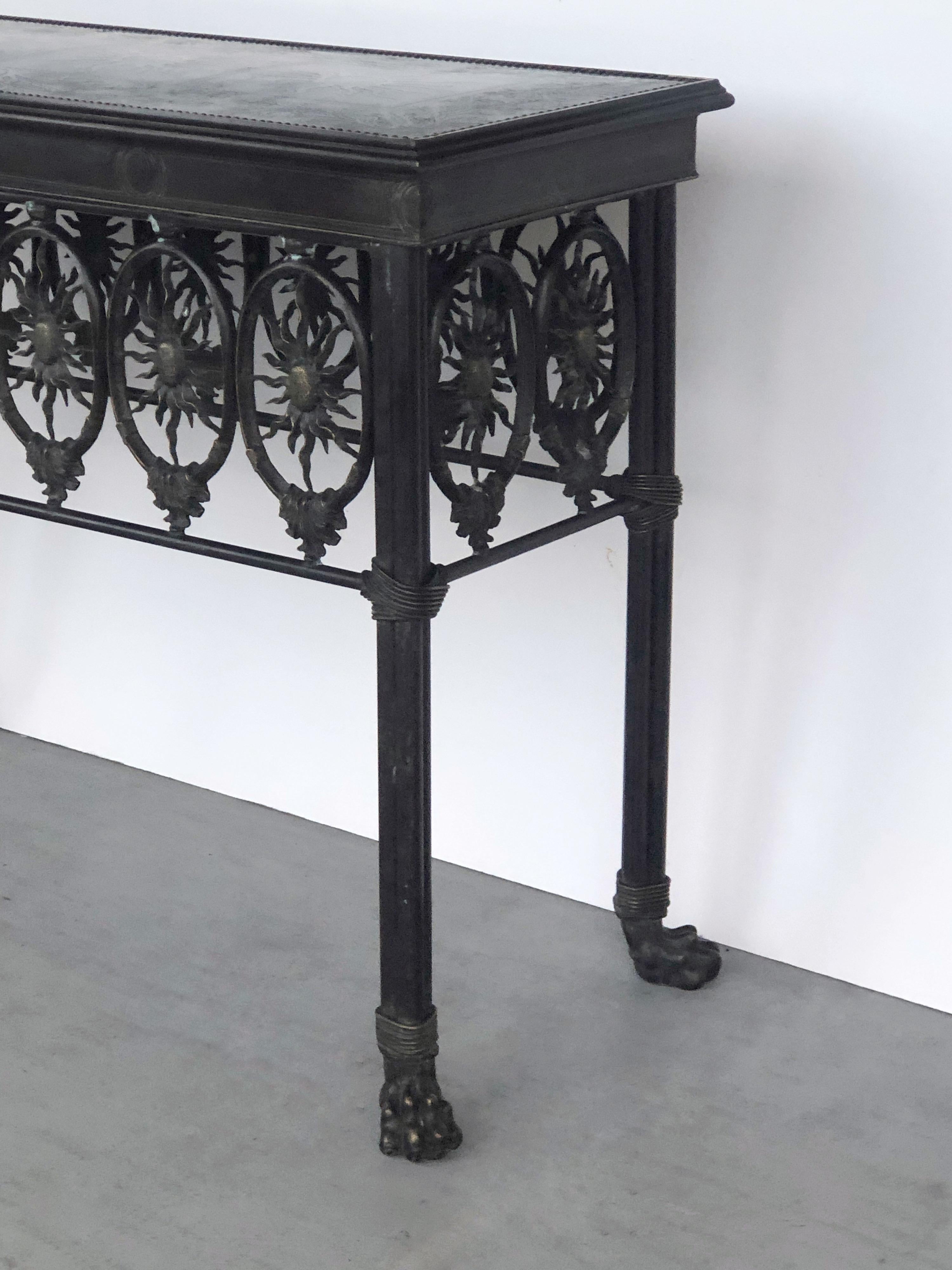 A bronze console table with sun and lion's paw motif.