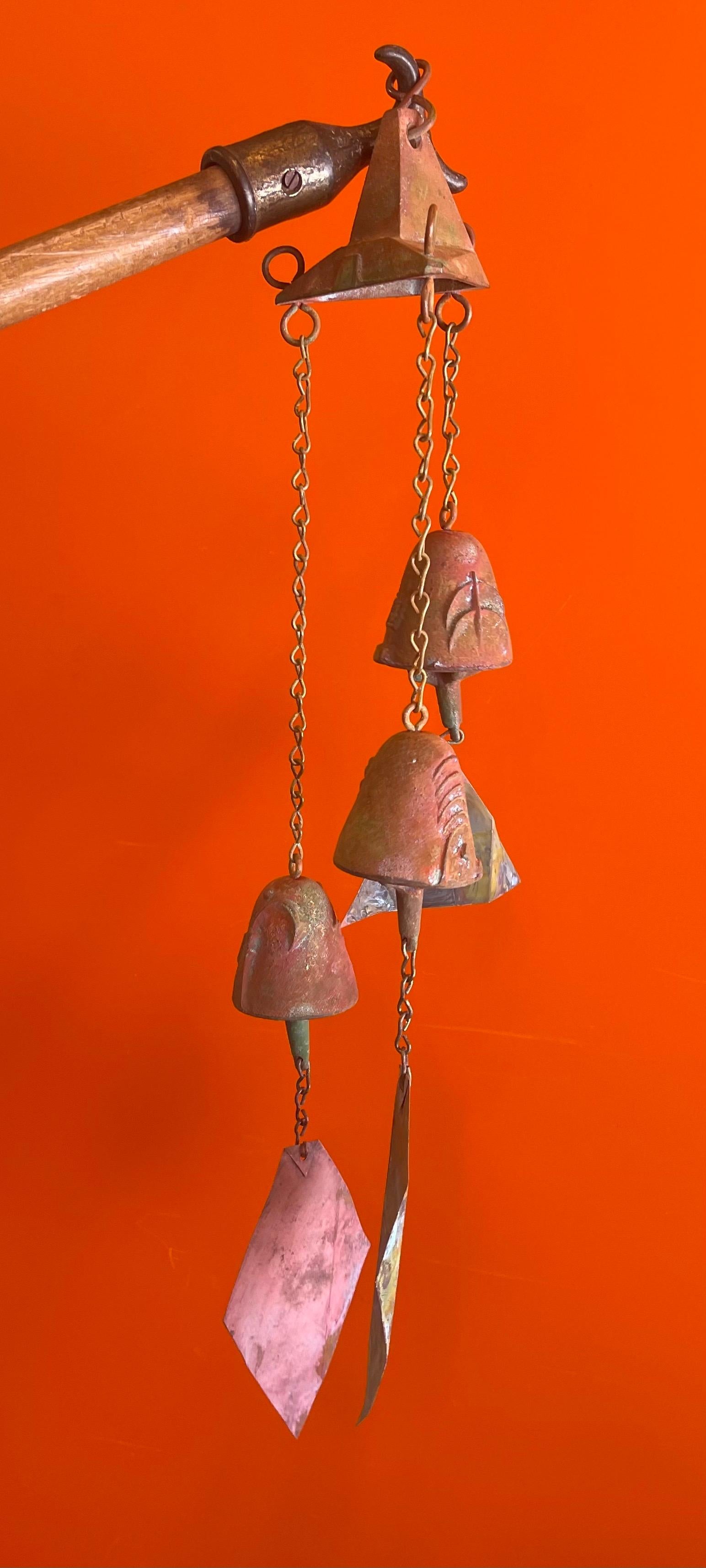 Bronze Cosanti windbell cluster with hanging bracket by Paolo Soleri, circa 1980s. The cluster combines three windbells beautifully suspended by delicate chains at different lengths from a flared funnel-shaped piece above. The bells have a stunning