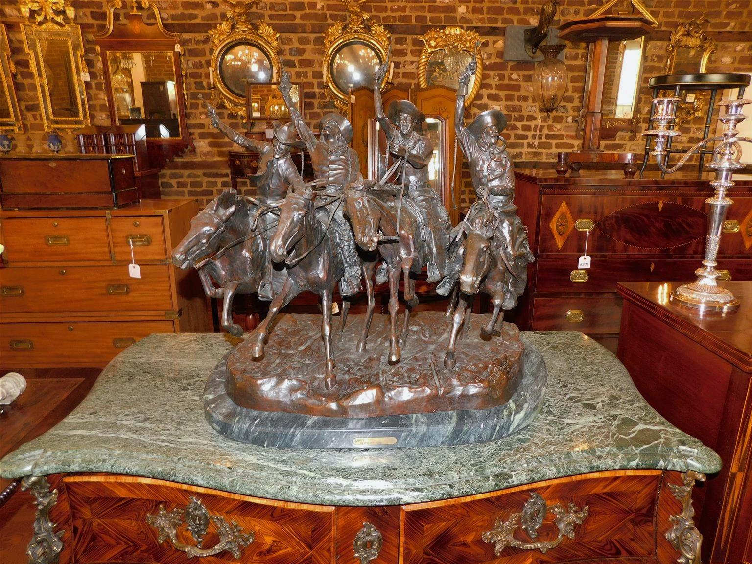 American bronze cowboy sculpture resting on oval molded marble base depicting cowboys on horses coming in to town from cattle drive. Bronze sculpture of Frederic Remington's 
