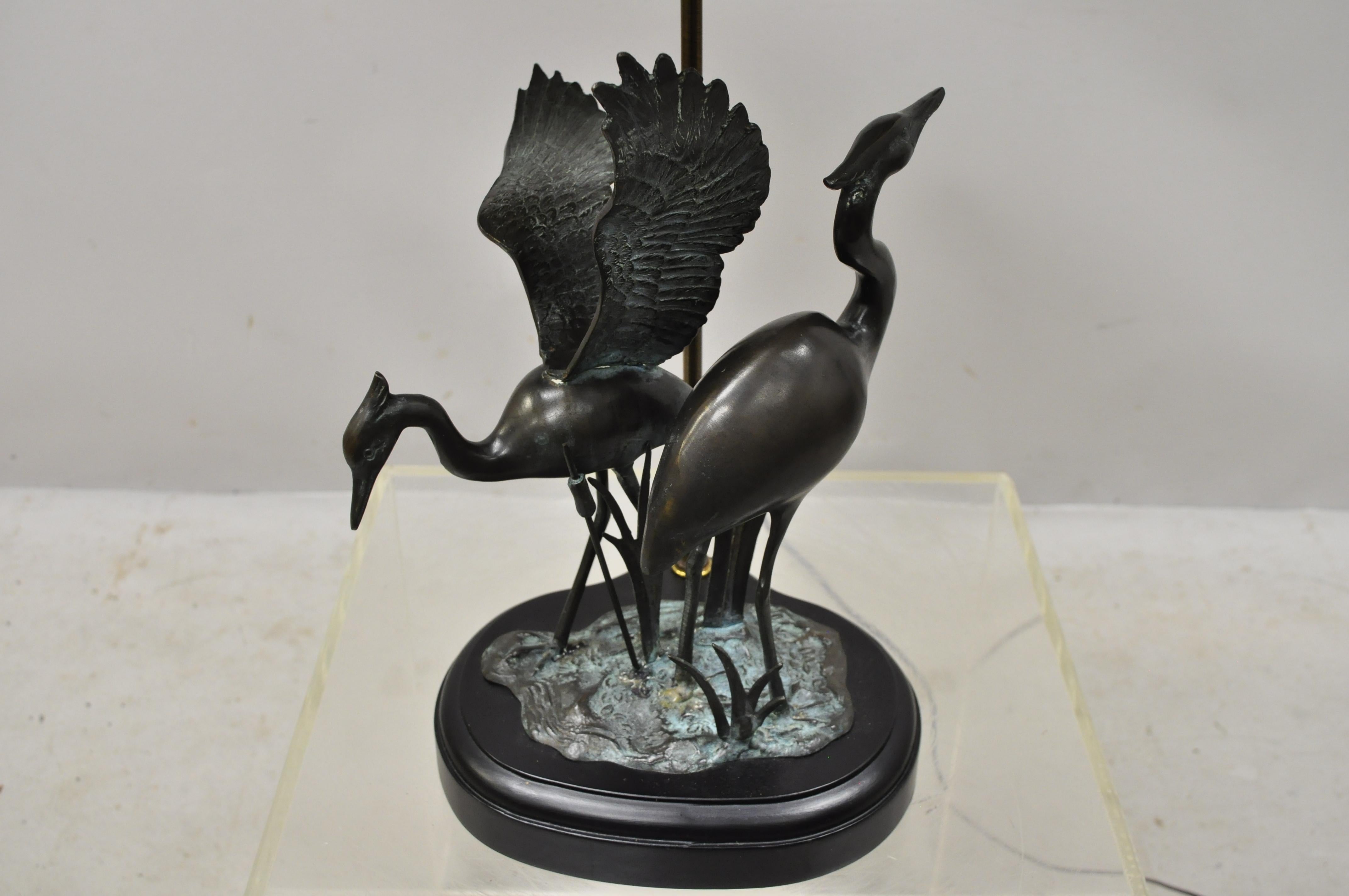 Bronze crane bird figures oriental Chinese style table lamp with black shade. Item features bronze crane figures, wooden base, original shade, quality craftsmanship, great style and form, circa late 20th-early 21st century. Measurements: 27.5