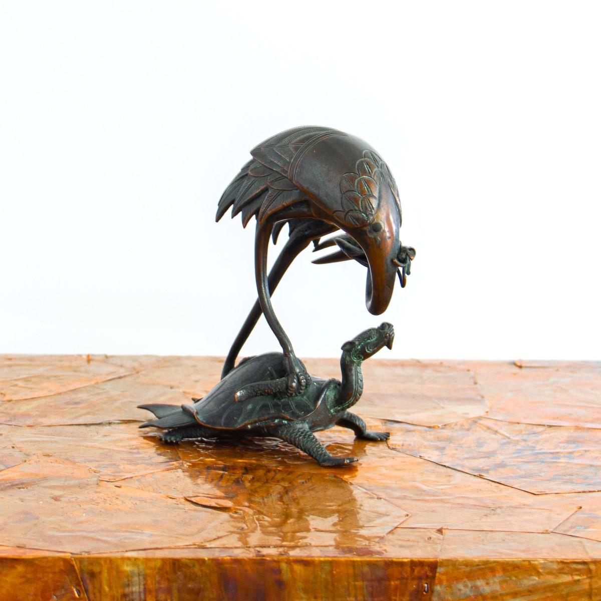 A small bronze table sculpture of a delicately carved crane riding on the back of a turtle, circa 1800s.

There are many folk stories involving cranes and turtles and close friendships In Vietnamese culture, the turtle and crane signify power and