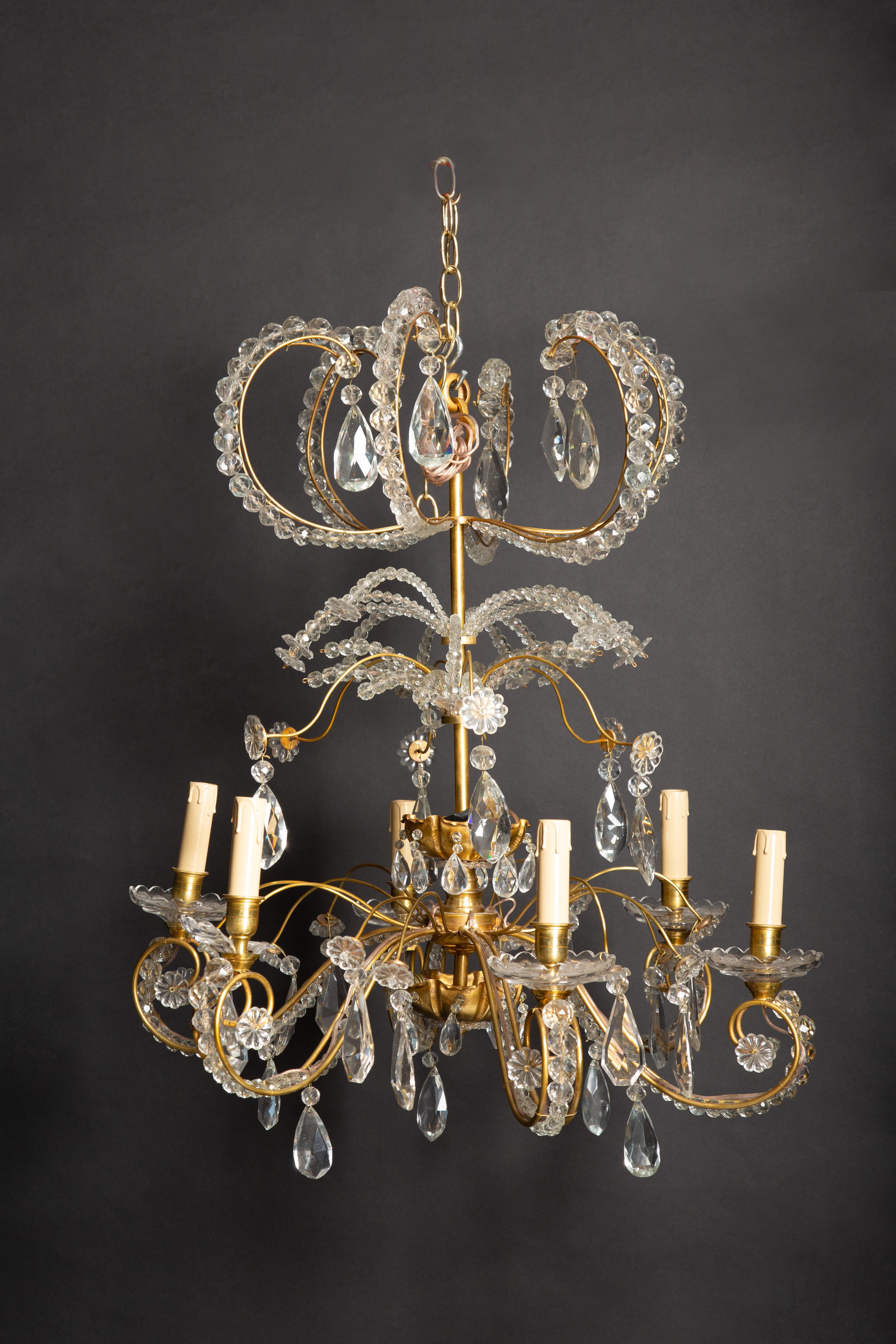 A bronze and crystal Jansen six arm chandelier having overall scrolling design and two inverted domes each having two lights circa 1940.