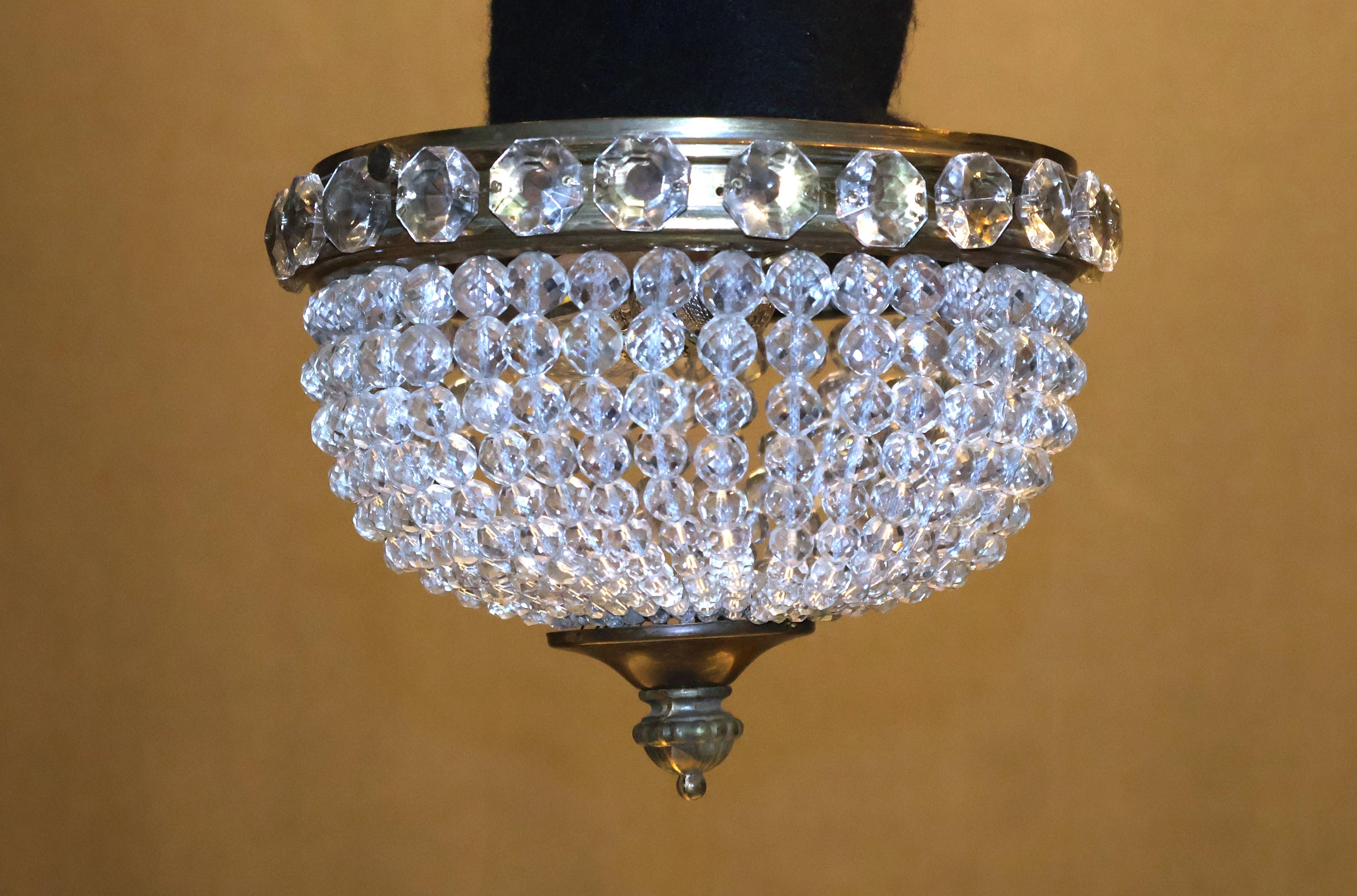 Un raffinato ed elegante ciondolo in bronzo e cristallo tagliato. 1 luce. 
Francia, circa 1930. 2 disponibili. 
Dimensioni: Altezza 7
