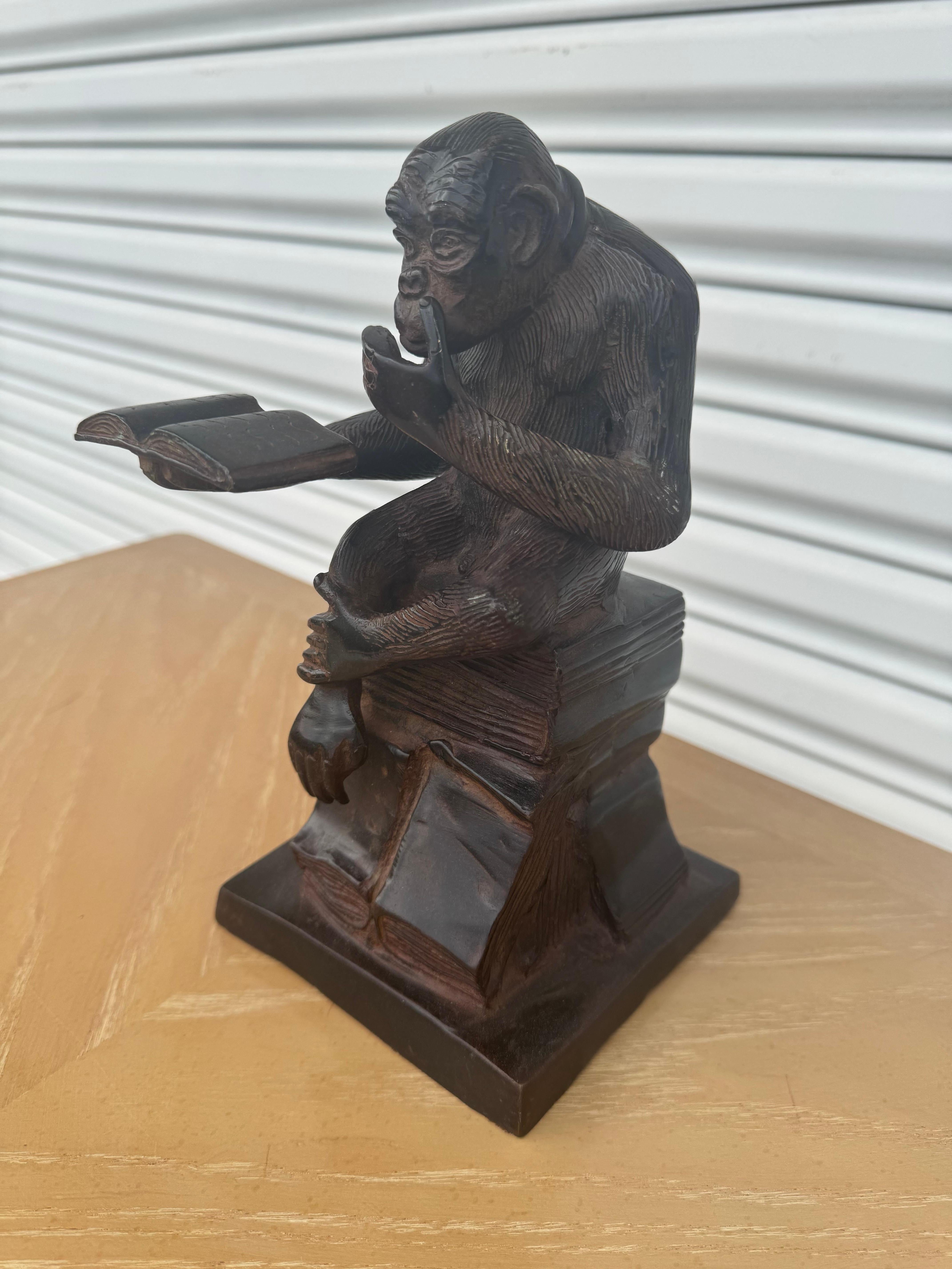 This is a bronze sculpture of Darwin's Thinking Ape.
The Ape is seated reading a book.
