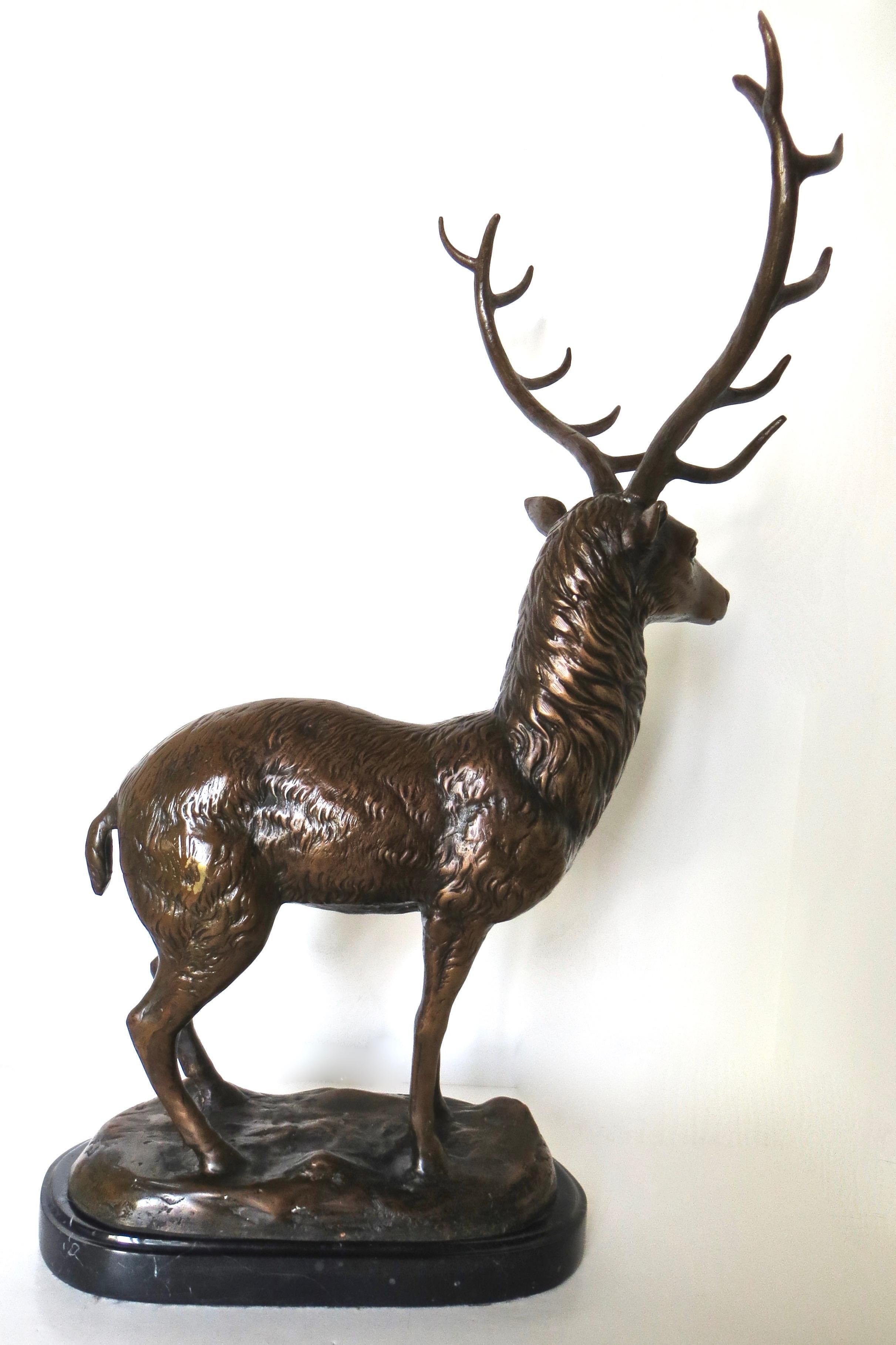 Large unsigned deer cast bronze stands prominently on a black veined marble base, seemingly surveying the landscape. With a twelve point rack between two large antlers, this deer bronze is quite well made with attention to detail on his fur coat and