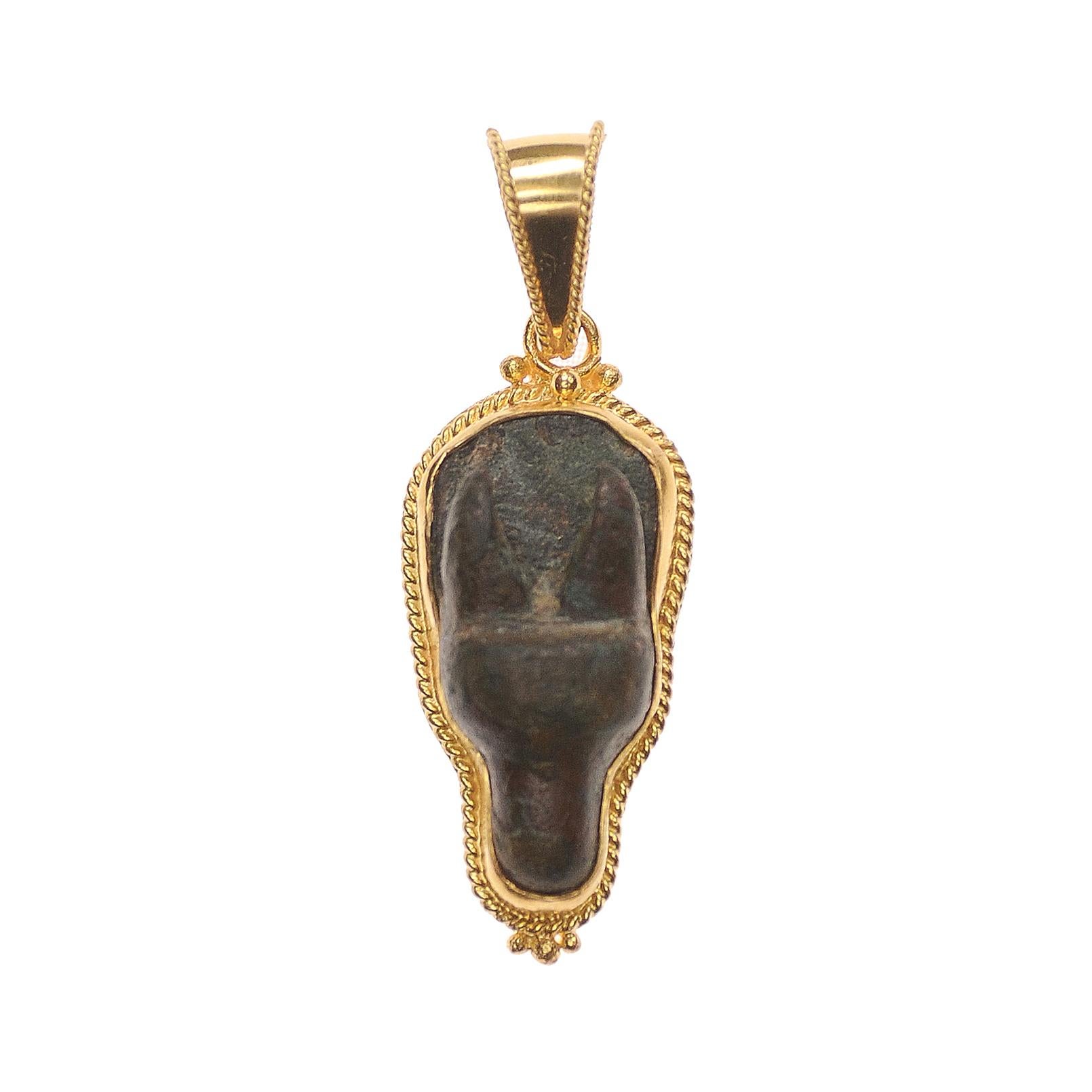 Un affascinante ciondolo a forma di testa di cervo in bronzo dell'Antico Impero Romano, rifinito con accenti in oro 21 carati e con una coda. La patina è meravigliosa e dimostra l'età del cervo. È datato approssimativamente tra il I e il III secolo