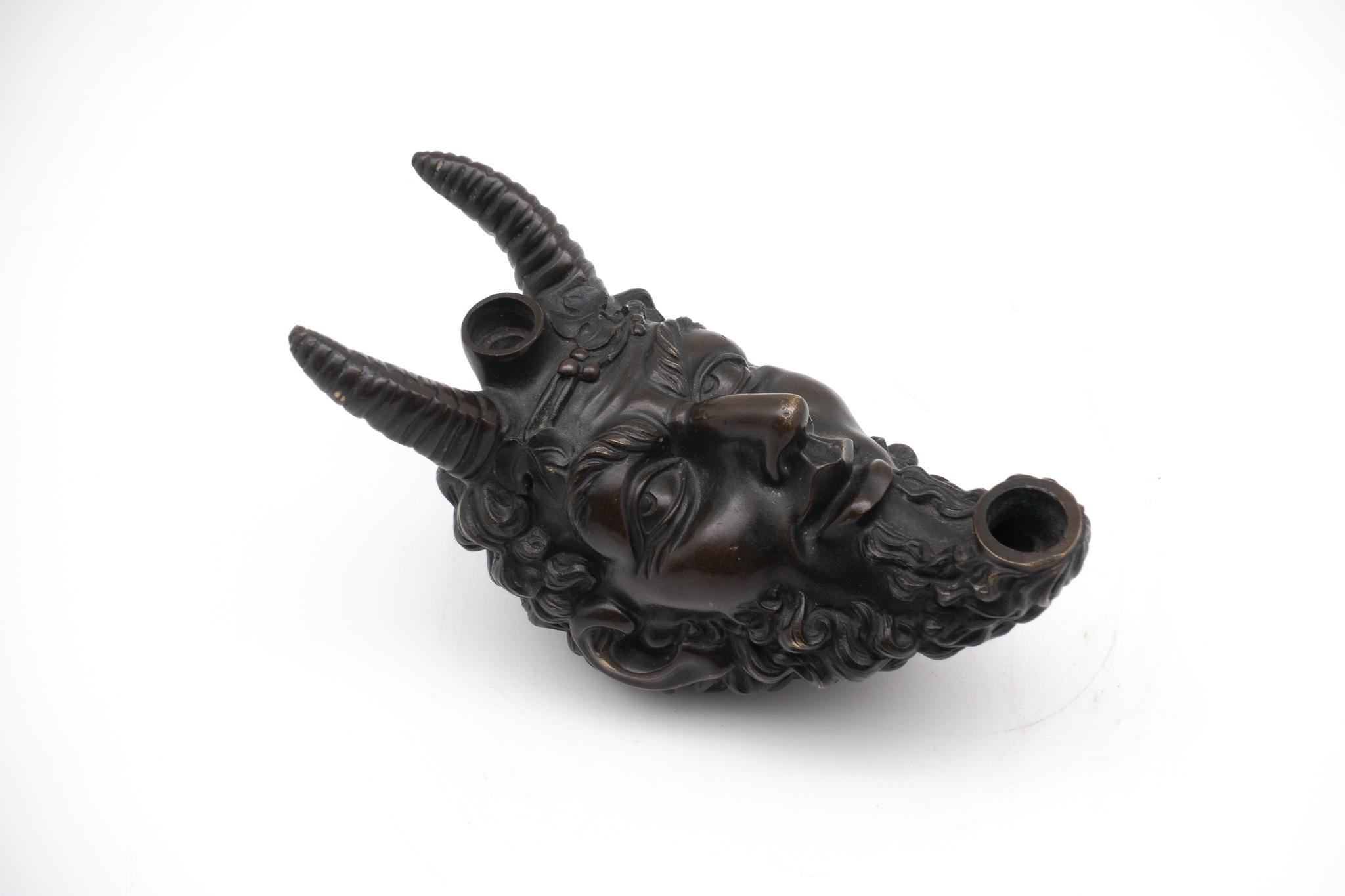 19th century continental bronze tobacco cigar lighter. There is a reservoir that can be filled with oil at the top of his head located between the horns. The tip of the beard is used for storing wick.