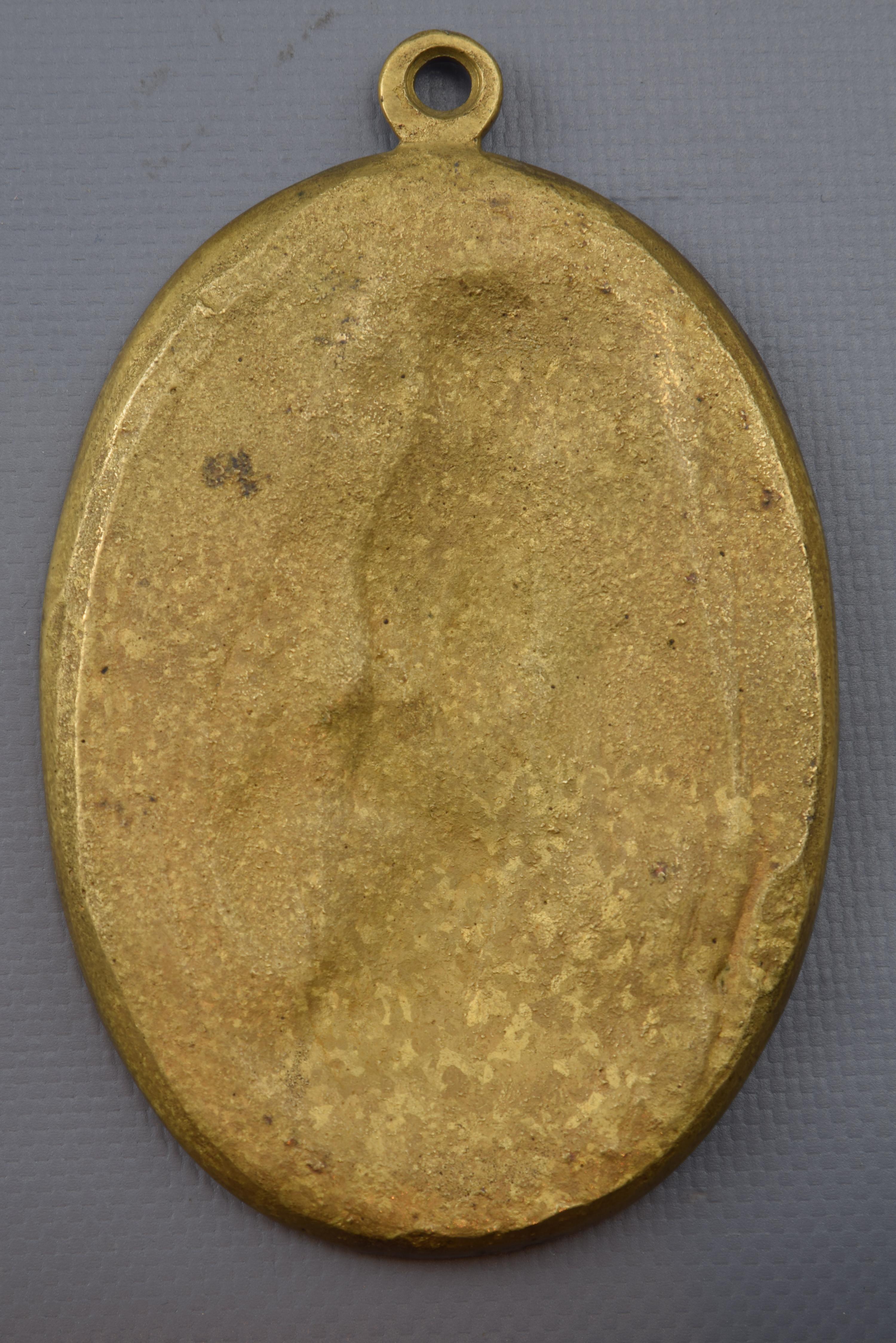 Devotional plaque, San Vicente Mártir, or Huesca or Zaragoza, or Valencia. Bronze, 19th century.
Oval bronze plate with a circular element at the top and a frame to enhance the relief of its interior, which shows a young man, dressed as a priest,