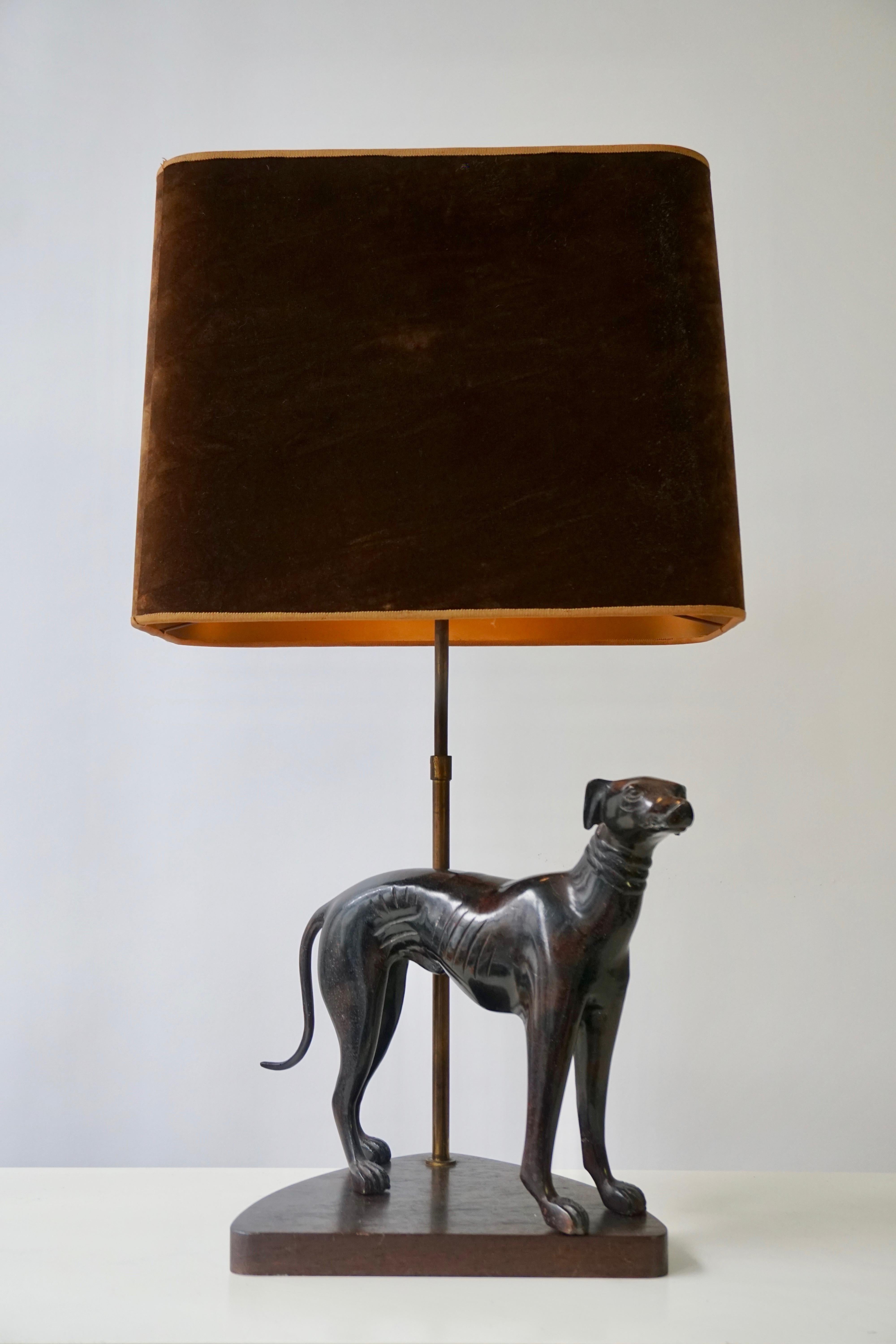 A charming table lamp with a bronze dog created at the middle of the 20th century, standing on an aged, wooden pedestal.
Wired as a lamp with a slender, tinted brass stem.
Height 71 cm.
Width 40 cm.
Depth 26 cm.