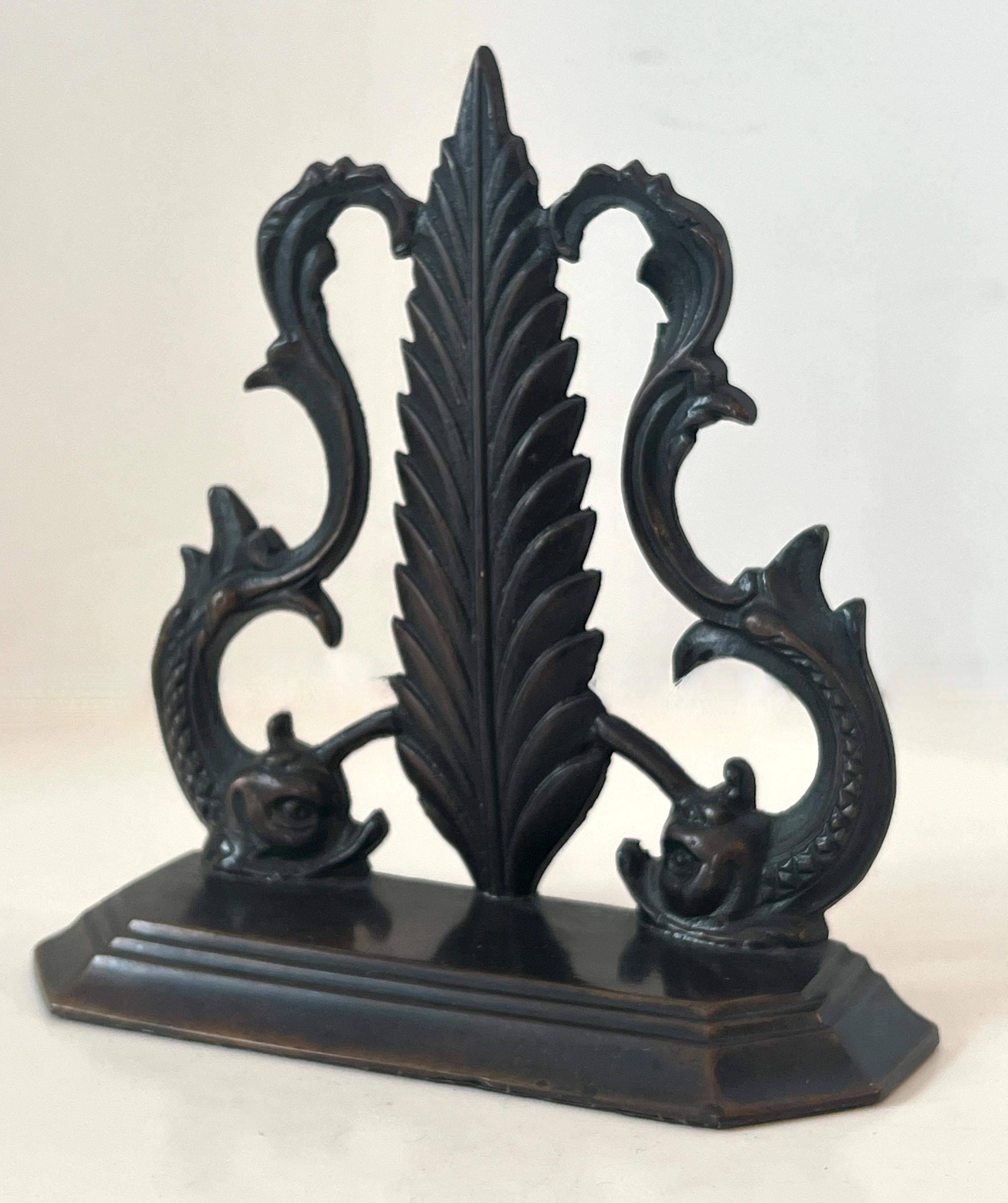 An Bronze door stop with Dolphin Serpents and a center leaf.  

The design is a compliment to any space and very functional.  Heavy enough to hold a door on a windy day and light enough to move from room to room.

A great piece that could also be