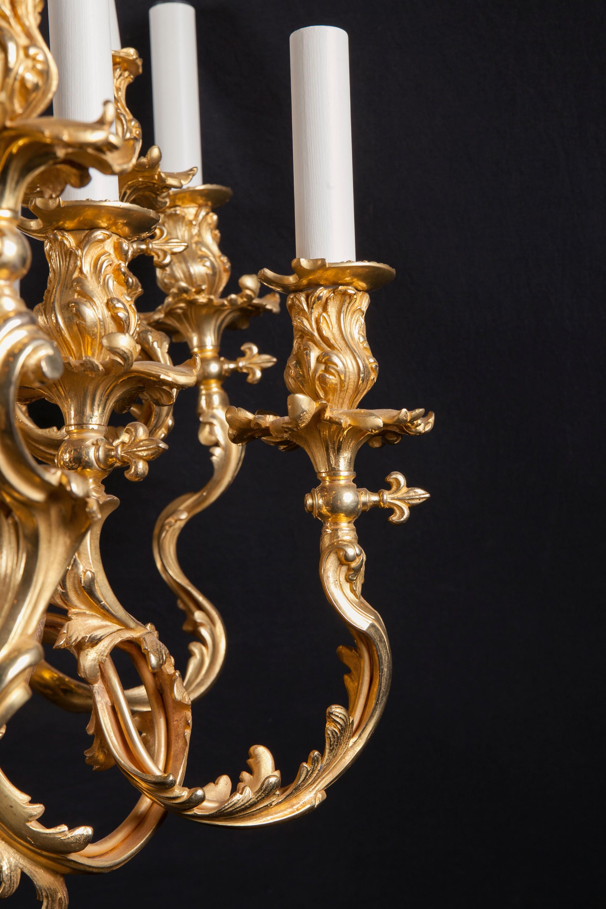 This fantastic Rococo chandelier features finely chiseled bronze d’ore. The piece was originally made for gas and uniquely sports horizontal fleur de lis key at the base of each cup to turn the flow of gas on and off. Dating back to the 19th