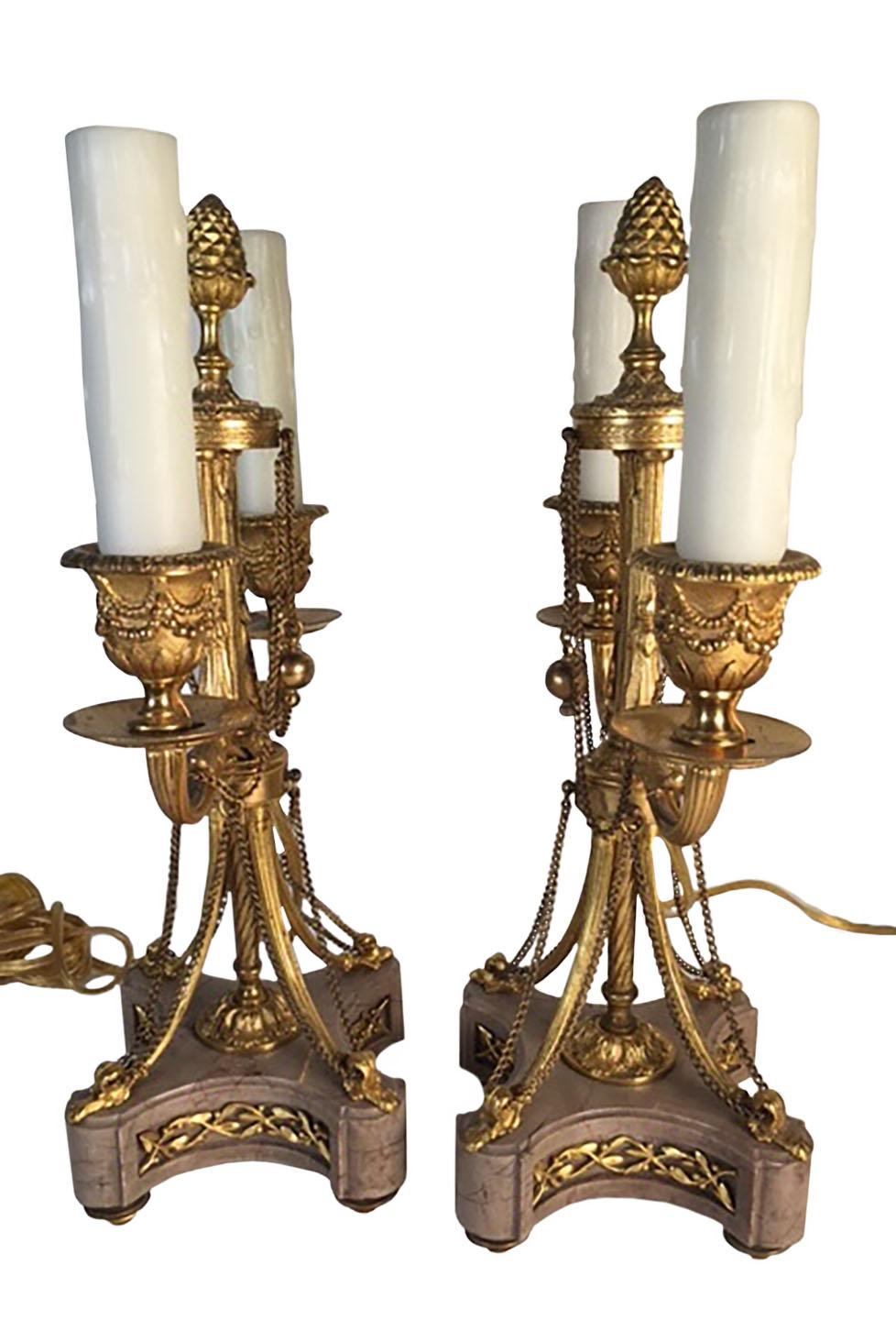 A pair of Louis XVI style bronze doré bright gilded original finish with chains connecting the marble base to the top. Fitted for electricity ,French circa 1860.