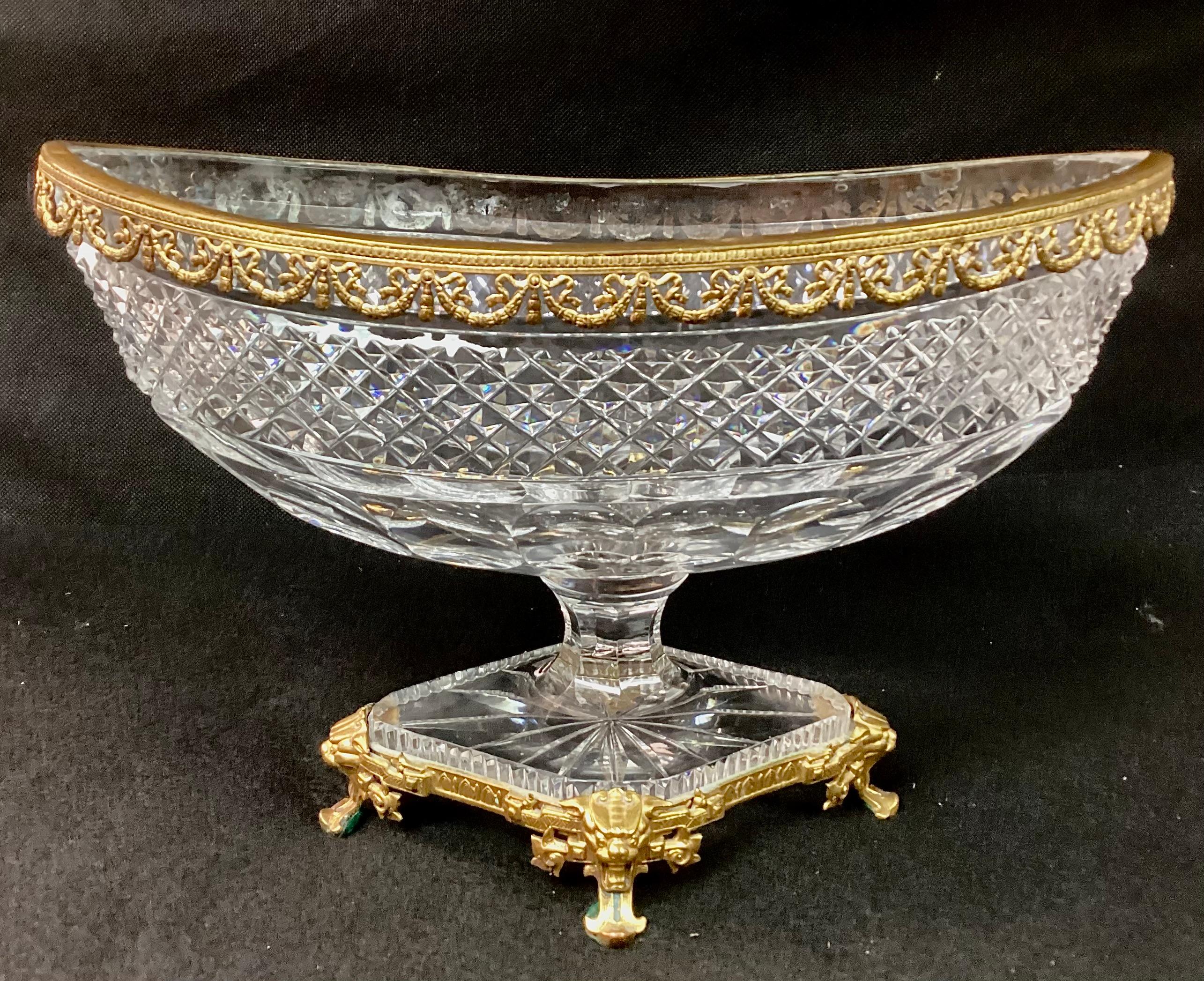 Exquisite Dore bronze and diamond cut crystal oval centerpiece in the style of Baccarat. Crystal bowl and pedestal stand on bronze lion paw feet. Attributed to Baccarat.