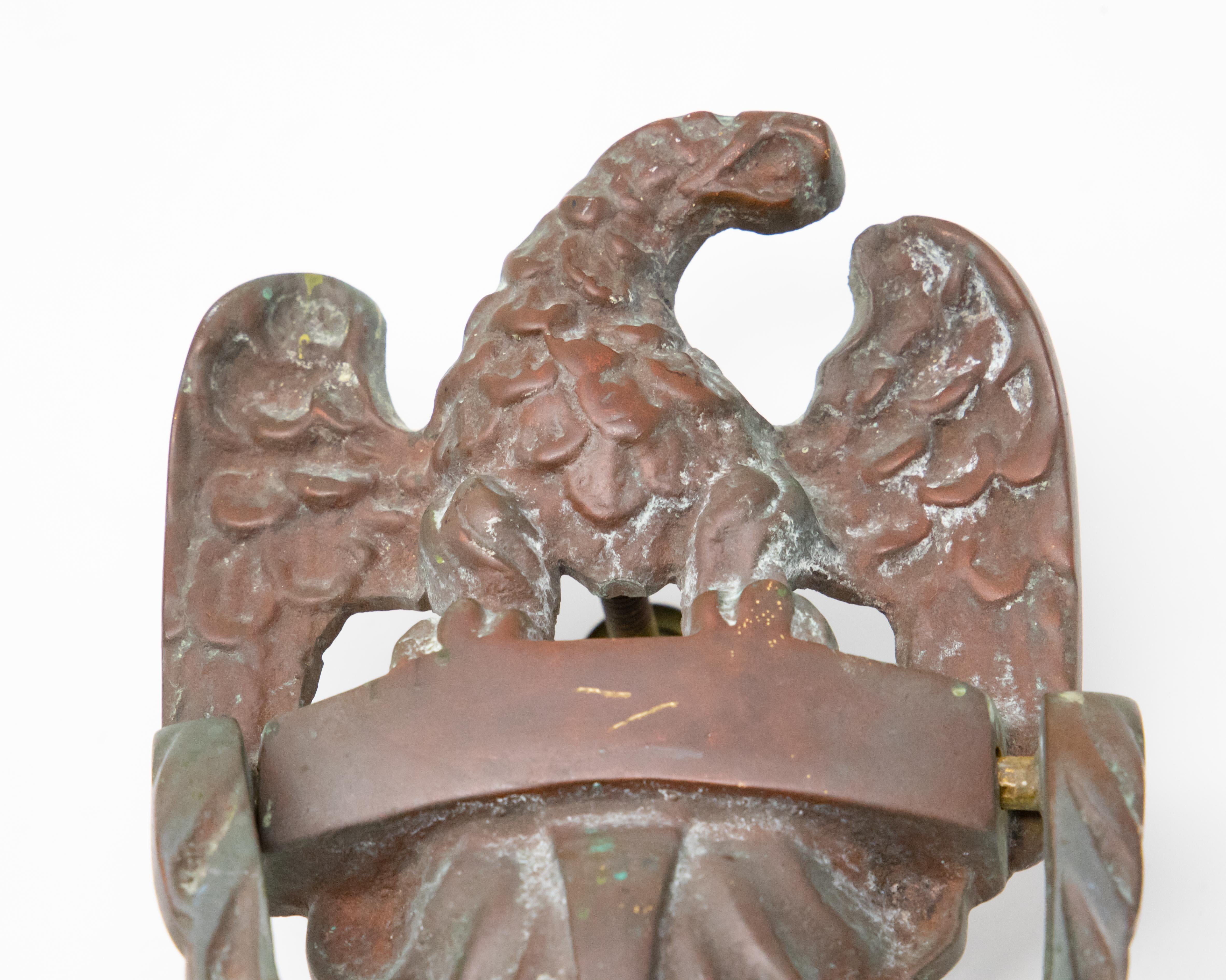 Offering this impressive bronze eagle door knocker. An eagle sits atop with wings spread. Underneath him is a foliate detail and the knocker.